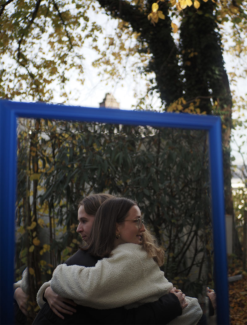 Die Protagonistinnen in einer Umarmung. Die Blicke abgewendet. 