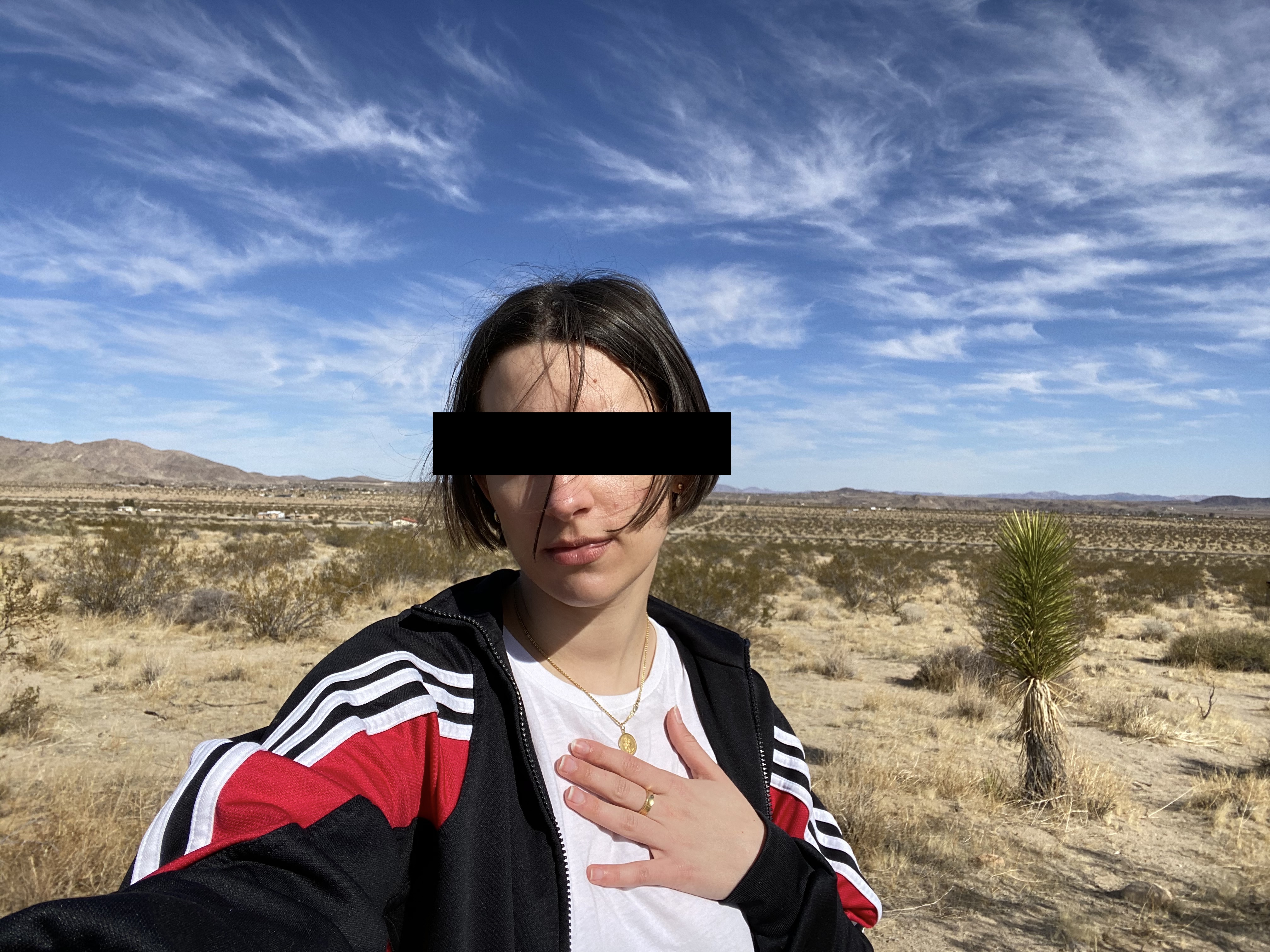 A mysterious woman wearing a track jacket in the desert