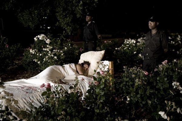 Figure 1 Anthea Moys, Nessun Dorma (None Shall Sleep Tonight)15, 2008. The artist´s performance in the rose garden of inner-city Joubert Park, Johannesburg, included an attempt to fall asleep guarded by four CSS Tactical Security guards, after Pucini´s aria Nessun Dorma was performed by professional opera singers Rheinald Moagi and Khotso Tsekeletsa, whilst Moys read passages from “Don’t Panic! Don’t leave for Perth! Stories from South Africans''.