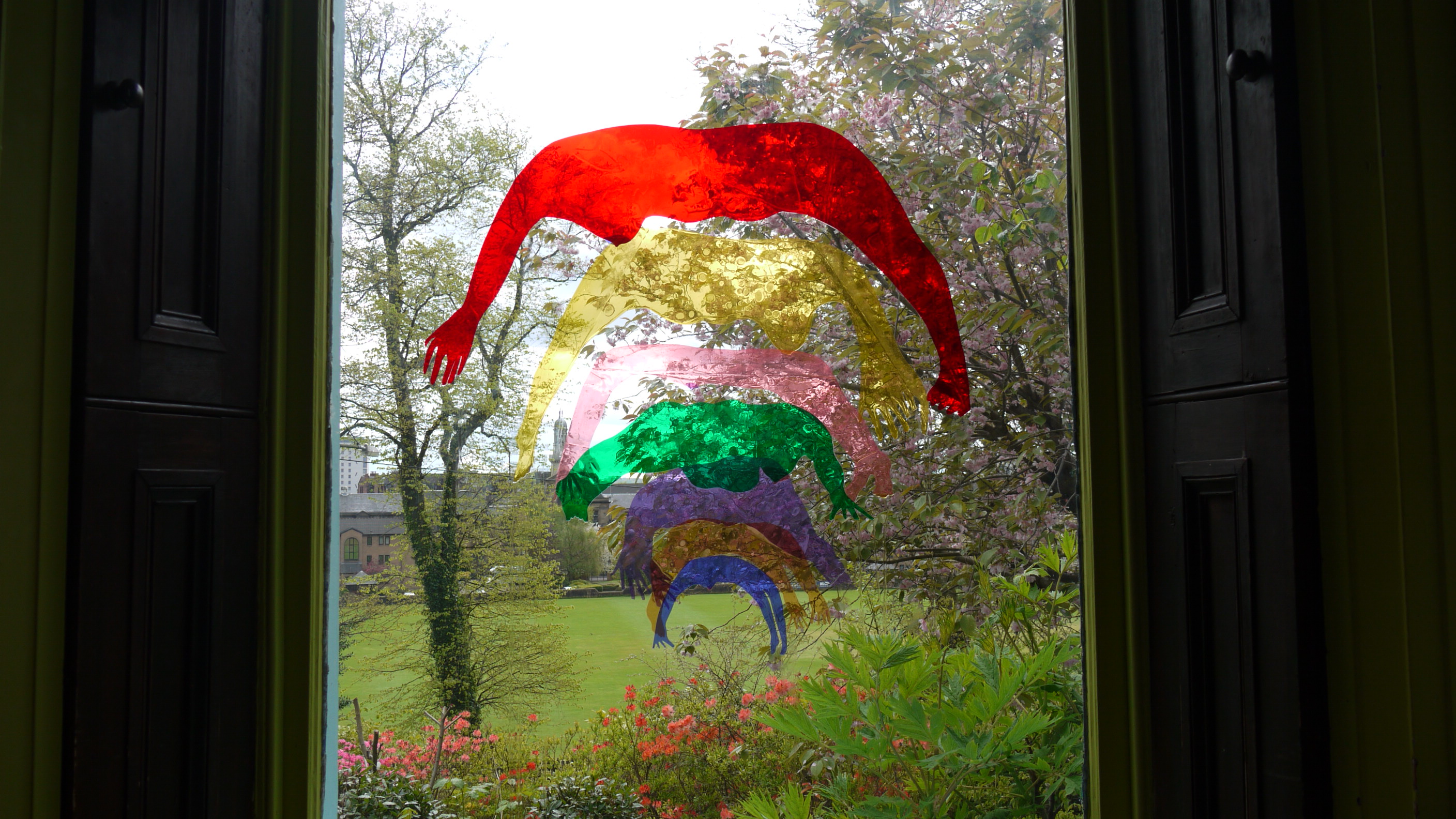 Window art installation: lighting coloured gels, cut out , collaged and pasted onto window glass with soapy water.