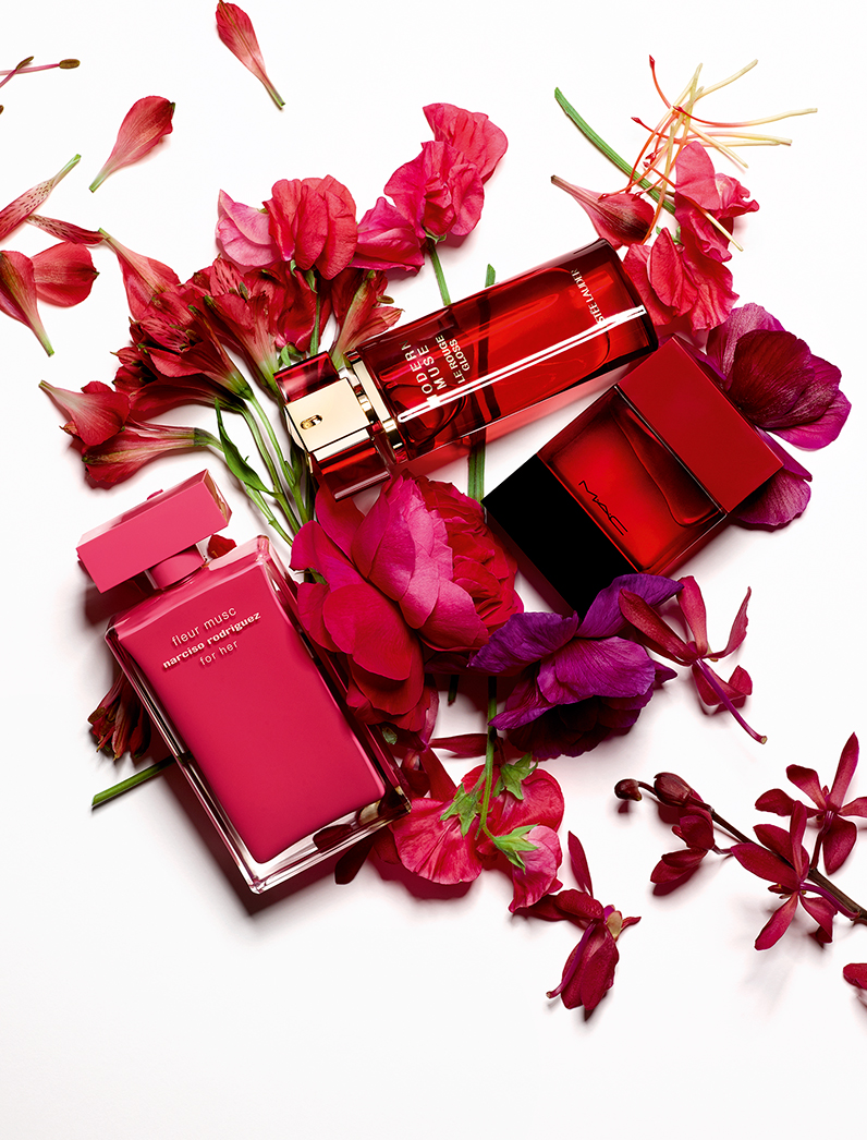 KMA photographer Isabelle Bonjean shoots red perfume bottles surrounded by red flowers on white background 