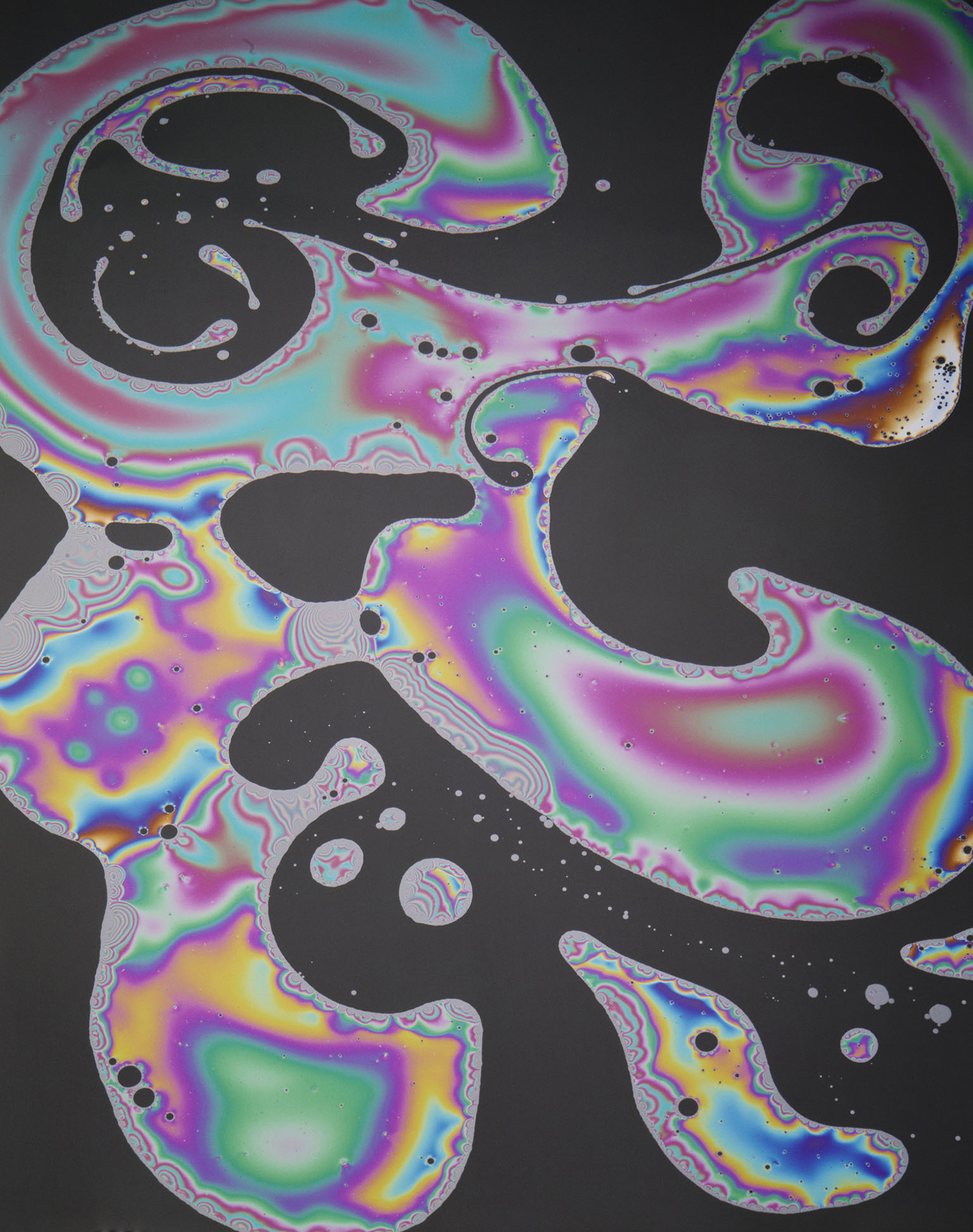 KMA photographer Daniel Schweizer shoots an abstract photo of rainbow bubbles splattered on a black background