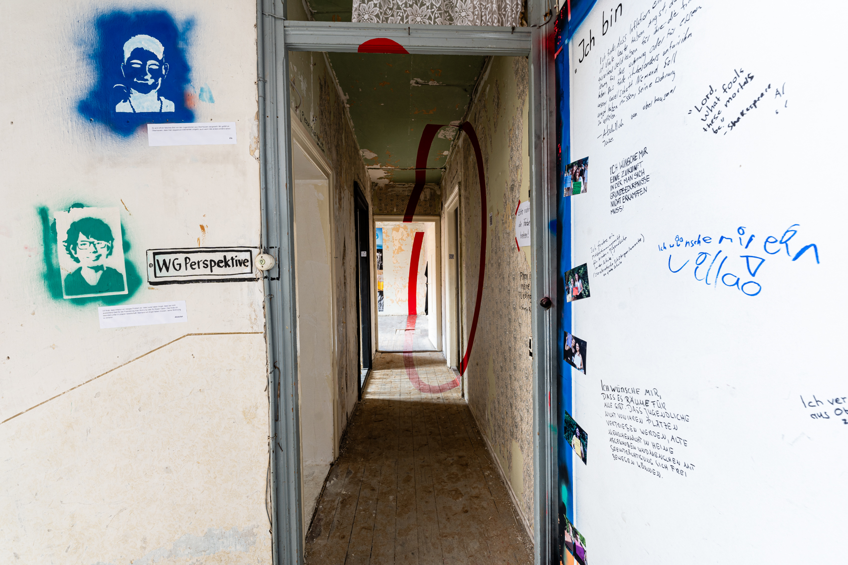 Bild 1 zu Form ist meine Lieblingsfarbe: Blick in den Gang der WG Perspektive. An  der Decke, der Wand rechts, dem Boden im Gang, sowie an der Wand im hintersten Raum, befindet sich ein etwa 20 Zentimeter breiter Streifen in roter Farbe. Insgesamt ergibt dieser einen Kreis. 