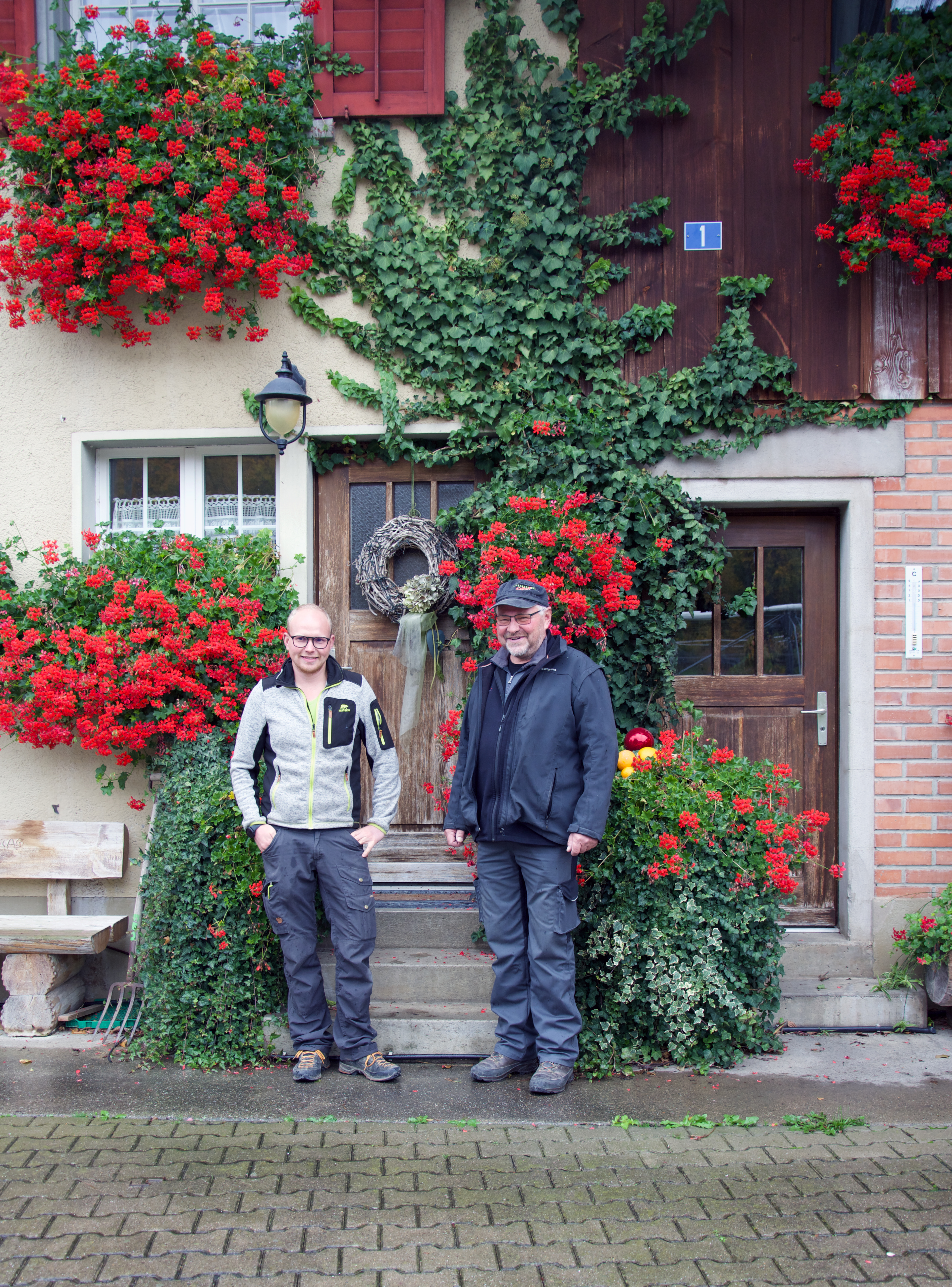 Peter Eichenberger and his Son Erik in front of their farmhouse.