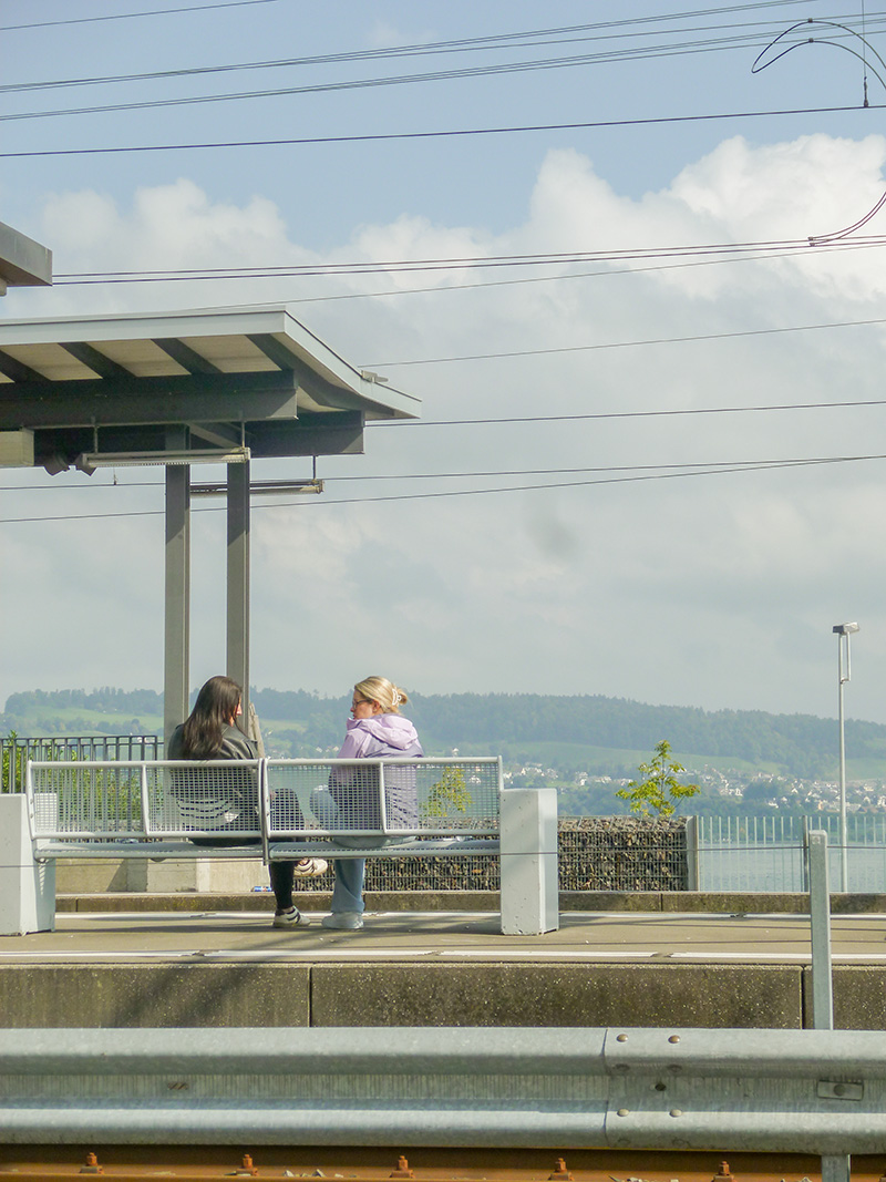 Zwischen Stationen. Treffpunkt auf der Bank am Gleis. Ein spontanes Gespr&auml;ch verbindet &ndash; alles rundherum in Bewegung.