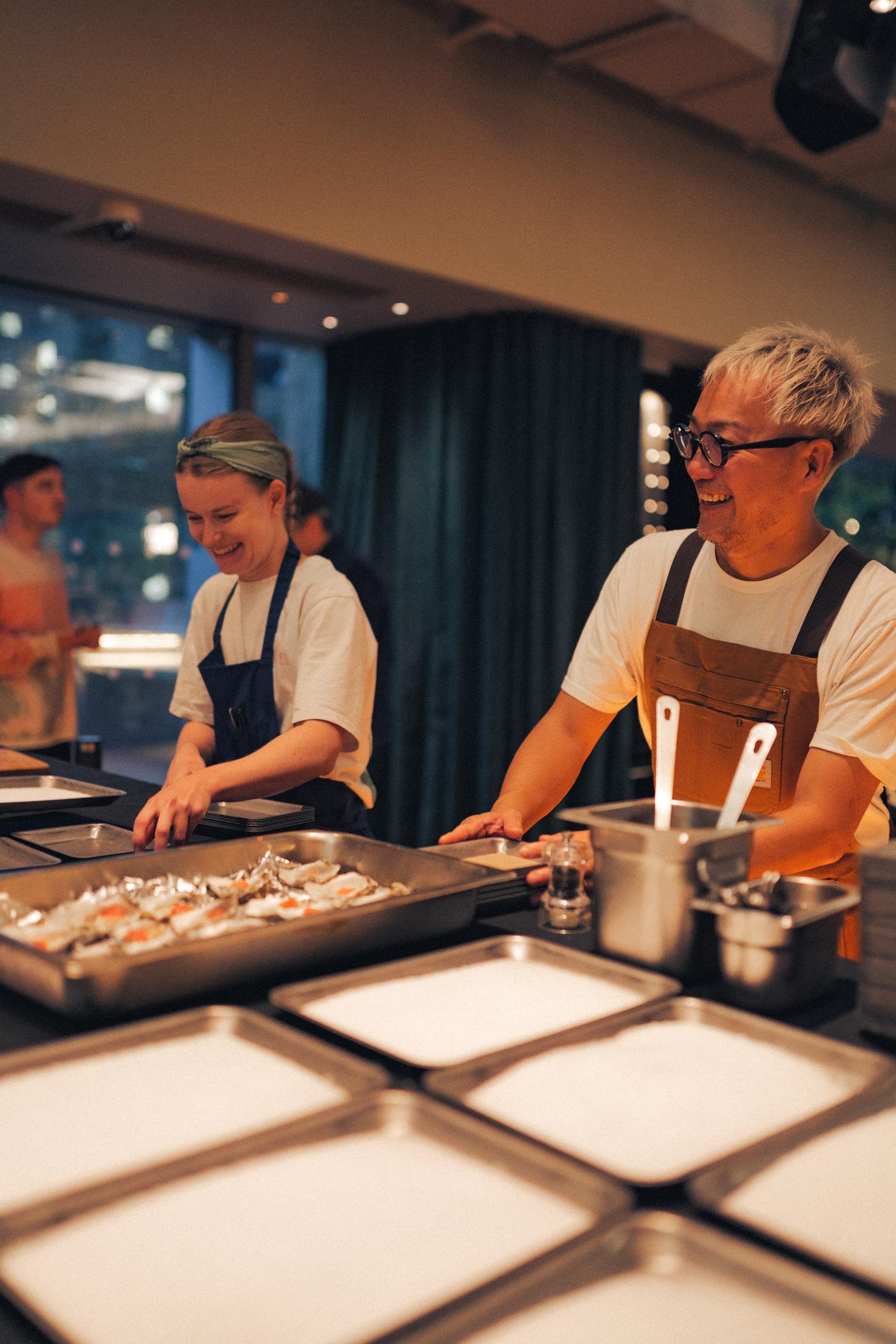 Chef Yoji-Tokuyoshi smiling while preparing dishes together during the Paired × Tate Modern event.
