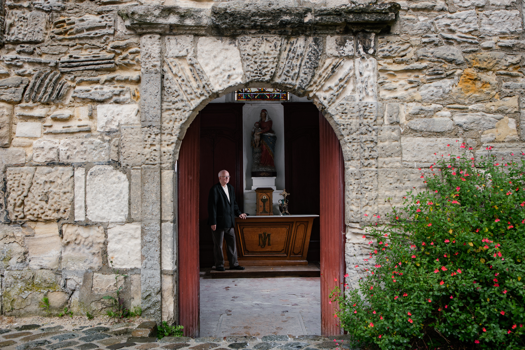 André Vantomme, former mayor of Clermont and former Senator of the Republic, by the Chapelle des Lardières. One of his great passions is churches. Over the years he has photographed thousands of churches around the world. "I am a nonbeliever, but for me, religion has no relationship with art. You can admire the beauty of churches without believing. When I was a child, my father and mother didn't go to church. But, I managed to make a separation between art and faith". André Vantomme is very attached to the Chapelle des Lardières: "Near the little church there was a very old tree. When I was mayor, I had to cut it down because it was dangerous. The people in the area were angry about this decision, but then the tree grew back on its own, from its roots".