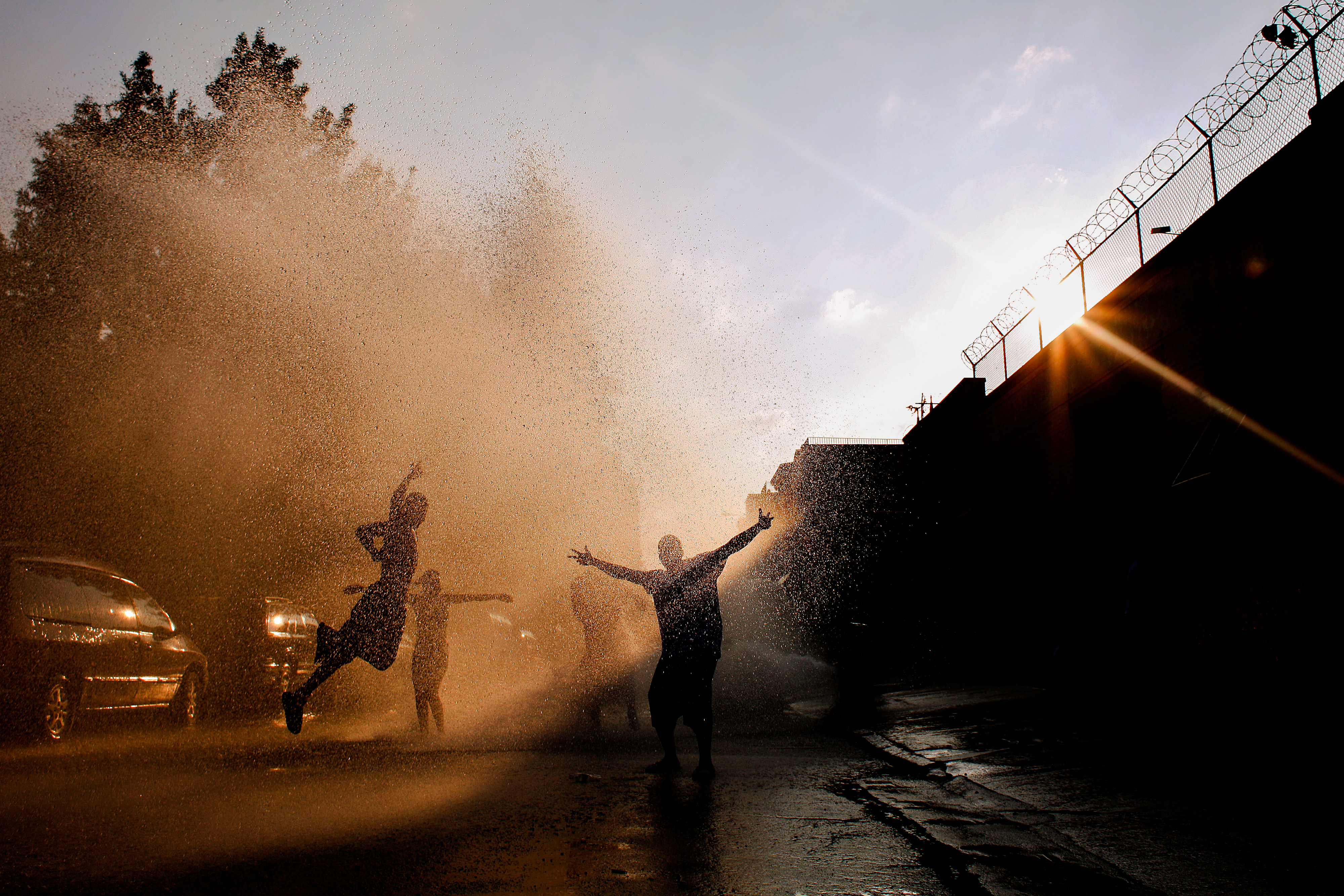 Kids play in an open fire hydrant on a hot summer day in East Williamsburg, Brooklyn.