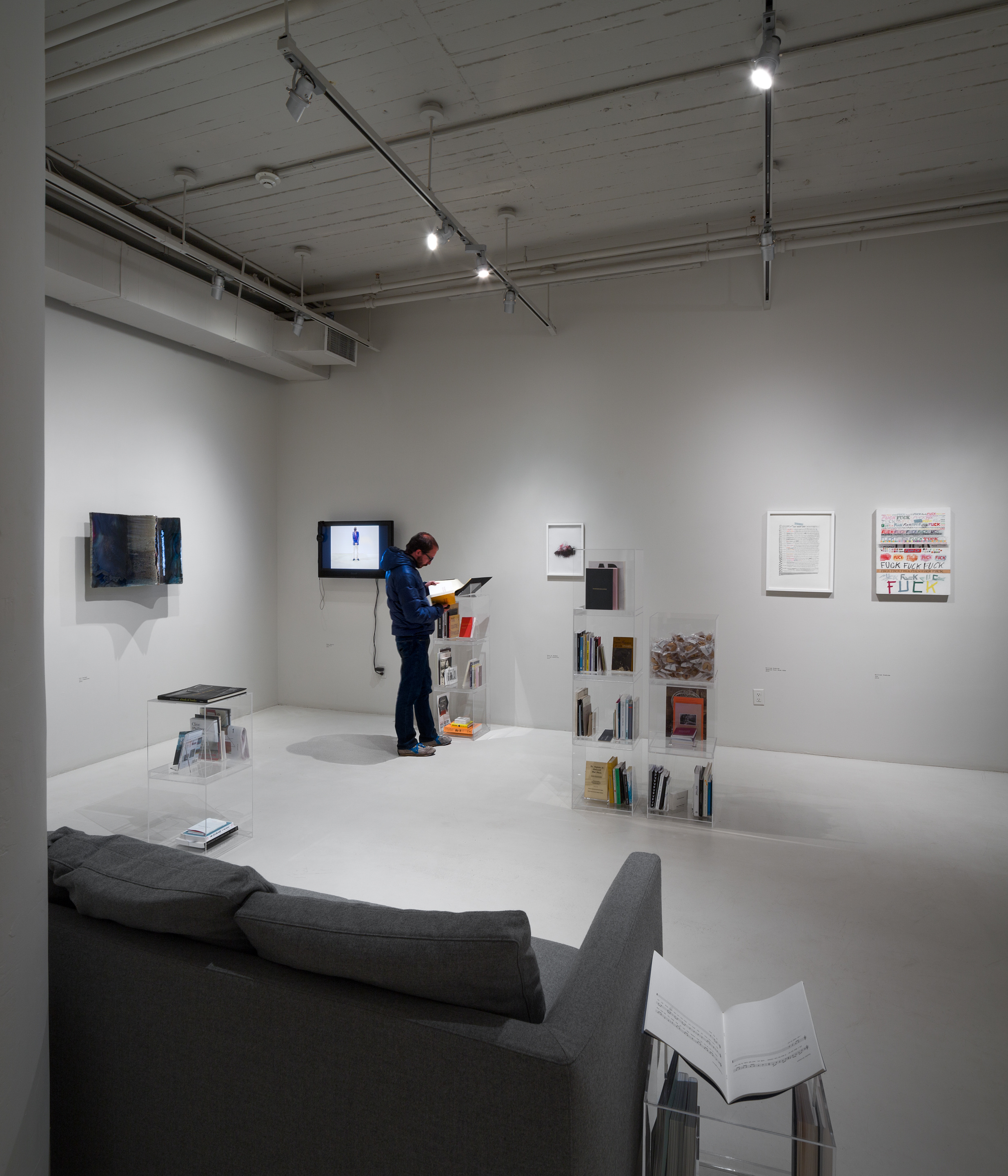 Installation shot, from left to right, Liz Larner iii (caesura) (2003), Oskar Dawicki I'm Sorry (2005), Sara Al Haddad It was beautiful (2012), William Powhida Updated Post Boom Odds (2014), William Powhida You (2010), UBIK Portrait of an Artist through his Statements (2012-14) and assorted books
