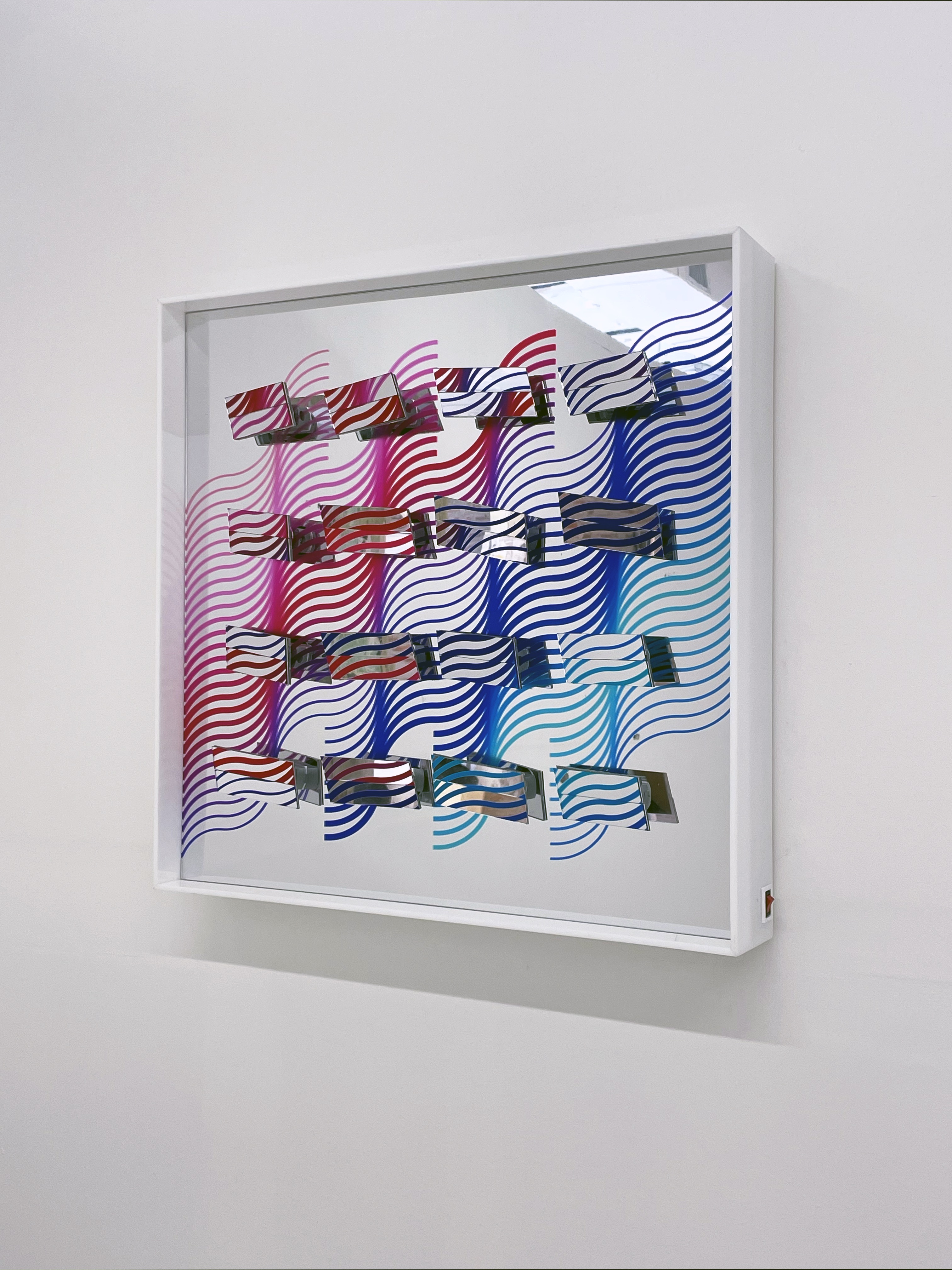 Synchromatismos #11, Serie Impercepción, 2021. Escultura cinética de acrílico, 16 piezas móviles en espejo, 16 motores, plaquetas de programación, 60 x 60 x 12 cm // ENG: Impercepción series. Kinetic acrylic sculpture, 16 mirrored moving parts, 16 motors, programming boards. 23.6 x 23.6 x 4.7 inches.