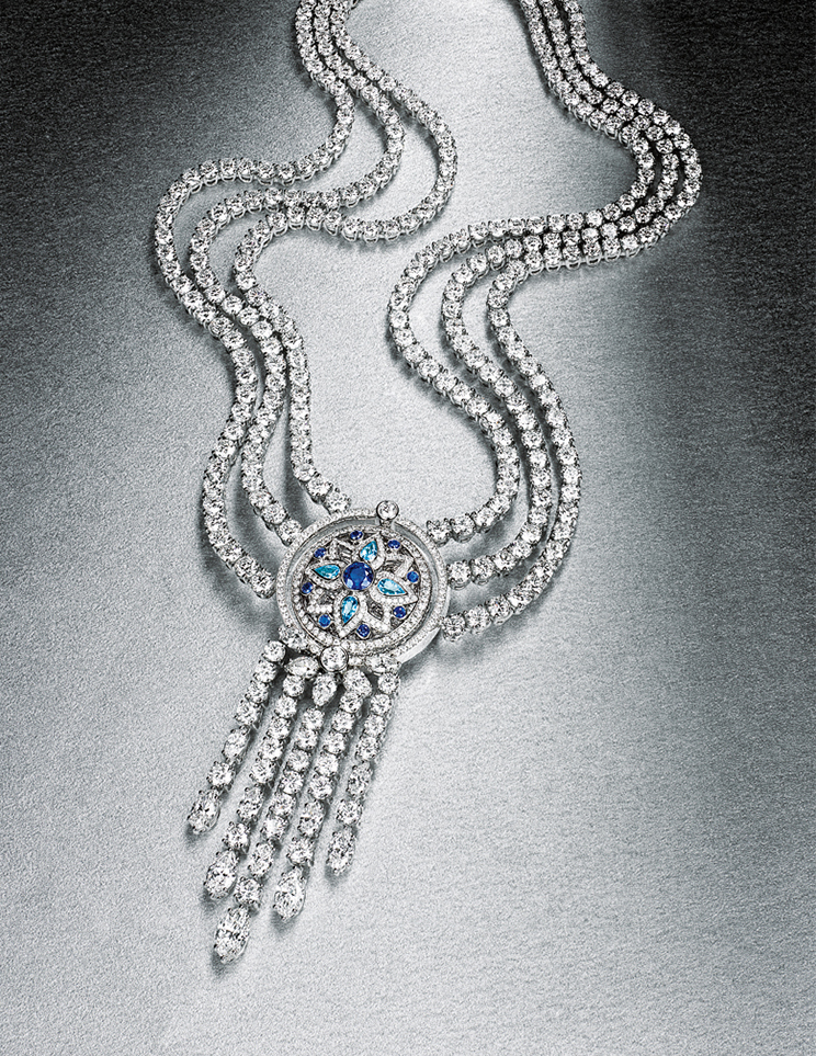 KMA stylist Sara Wacksman designs set for a photo of an elaborate diamond necklace resting on a shiny grey surface 