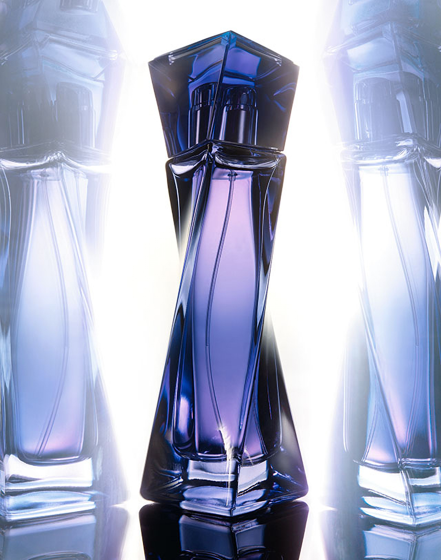 KMA photographer Daniel Schweizer photographs a purple bottle of perfume standing up on a mirror with a purple background