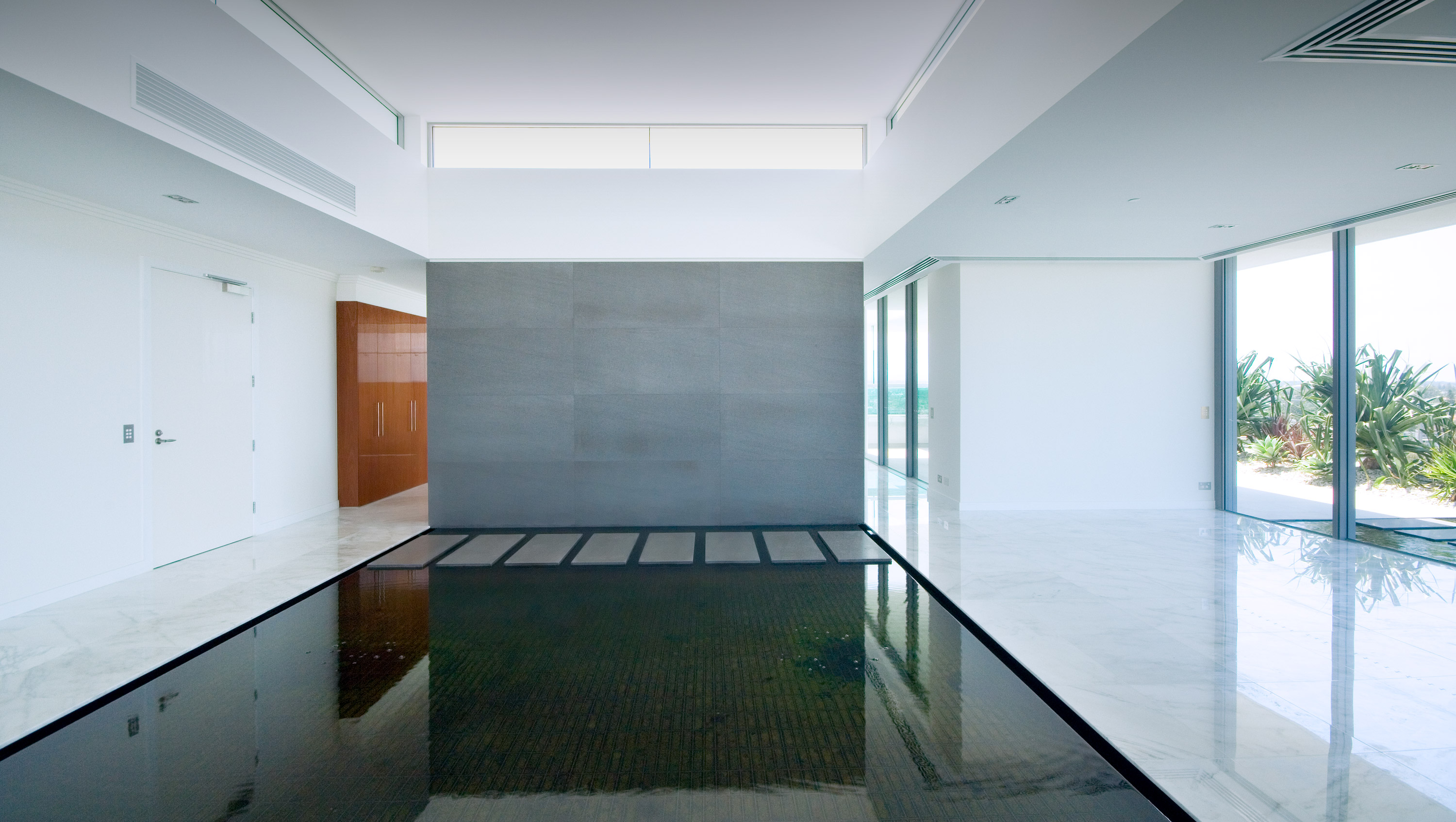 Minimalistic water feature with stepping pavers in the lobby space of Freshwater Point apartments.