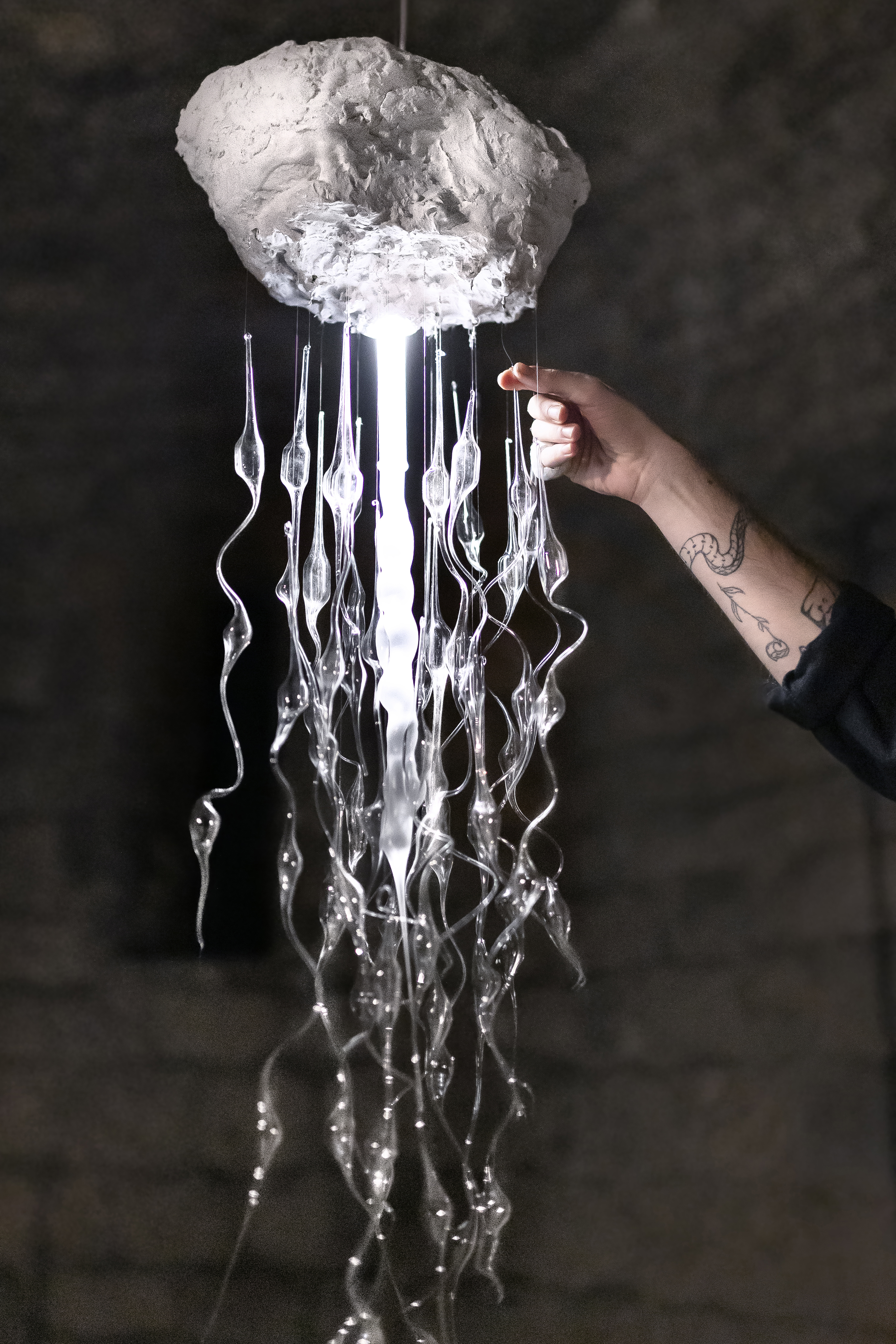 Detail of hand installing Chandelier made with blown glass exhibited at Capella de Sant Nicolau, Girona. Pelagia Noctiluca from Plaja Studio