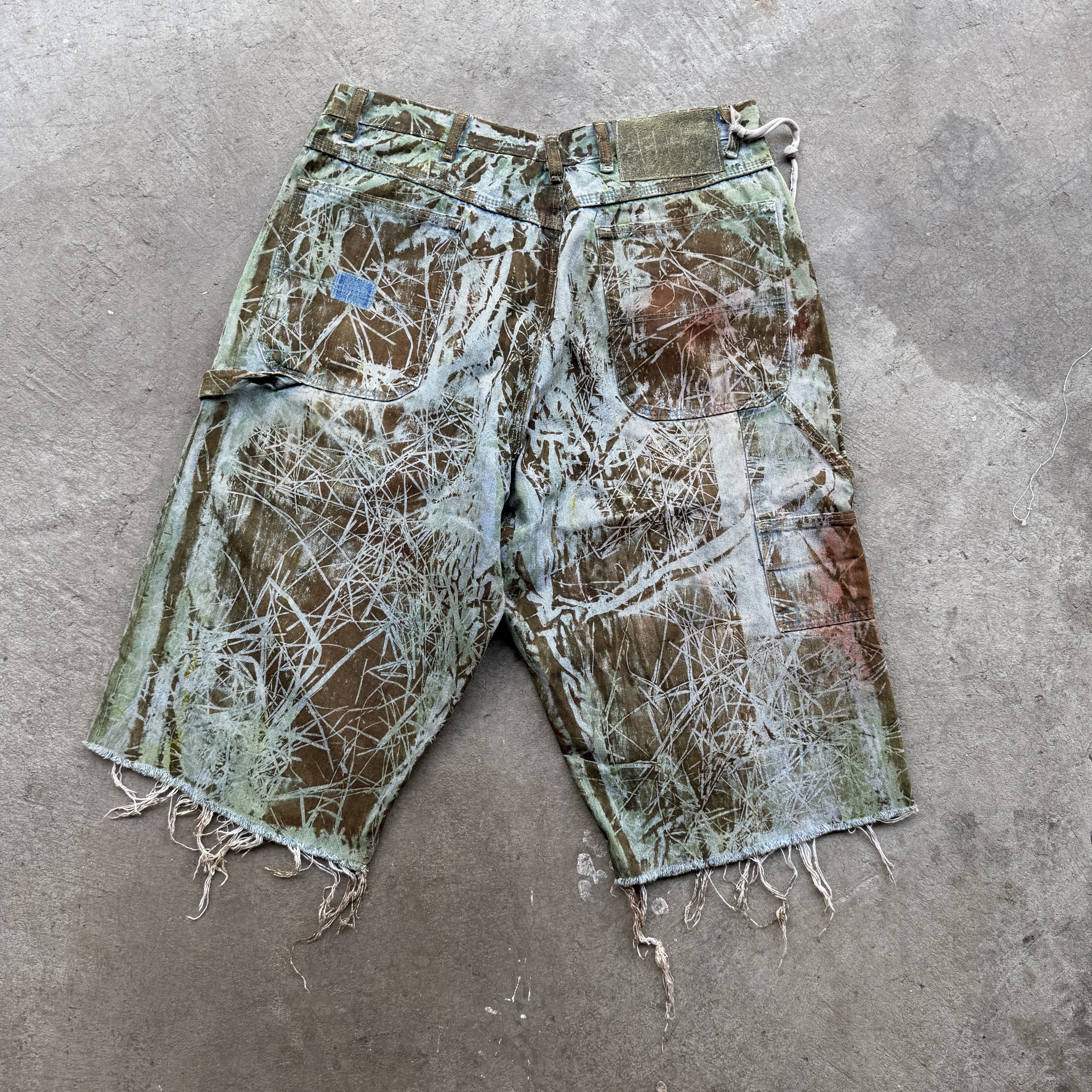 Reclaimed vintage surplus denim screen printed with grass pigment & textile dye. Tailored to give straight/wide fit. Fitted with dyed scrap chain, leather back patch, and custom buttons.