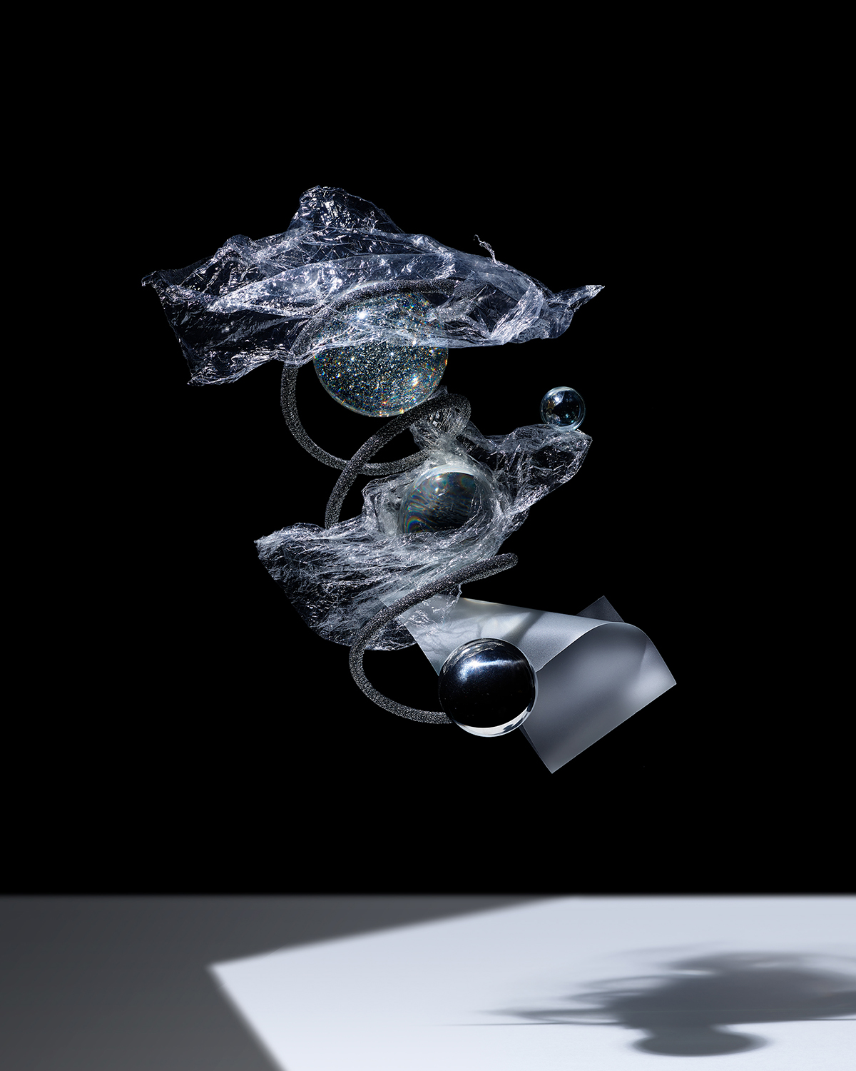 KMA photographer Isabelle Bonjean shoots grey black and white sparkling objects floating
