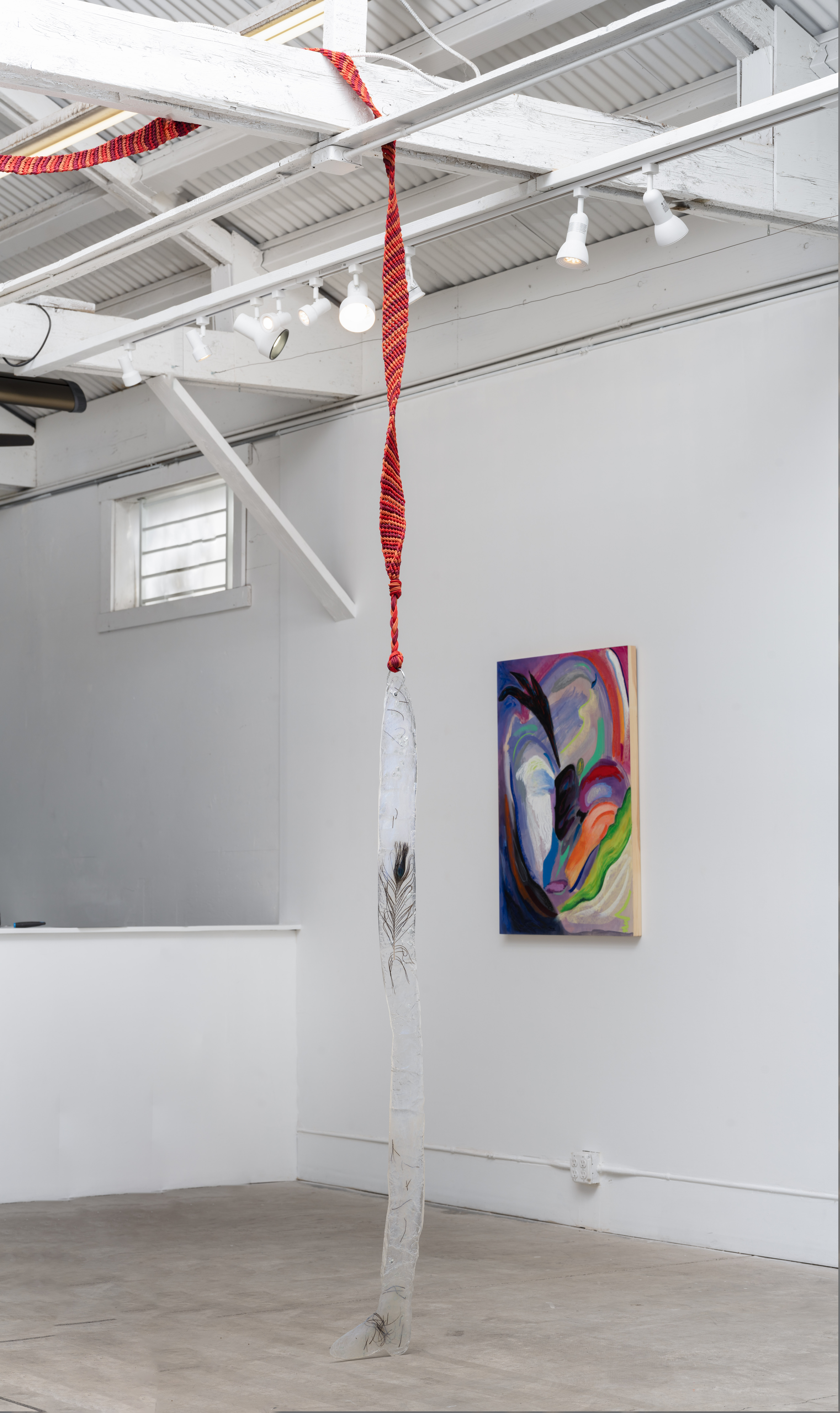 this body remembering yours, 2023. Resin, epoxy clay, peacock feathers, bracelet, metal and metal charms. 549” x 12”