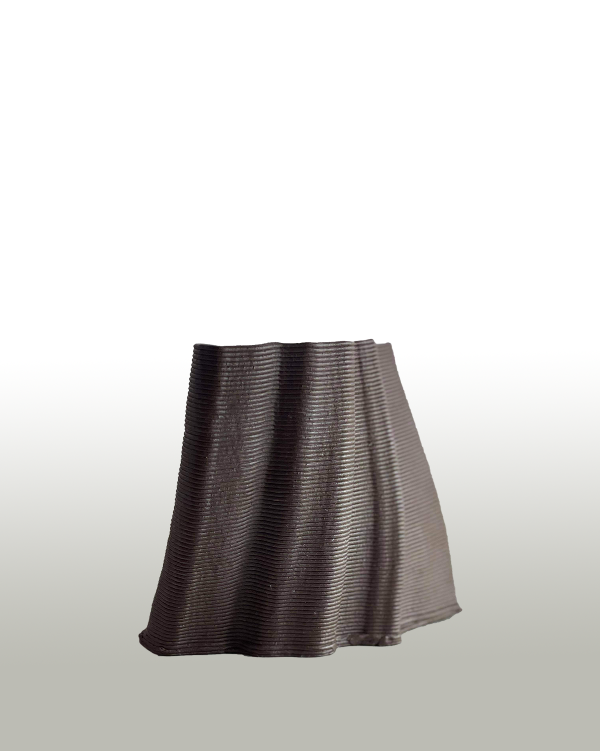 a brown wavy vase stands on a white to grey gradient