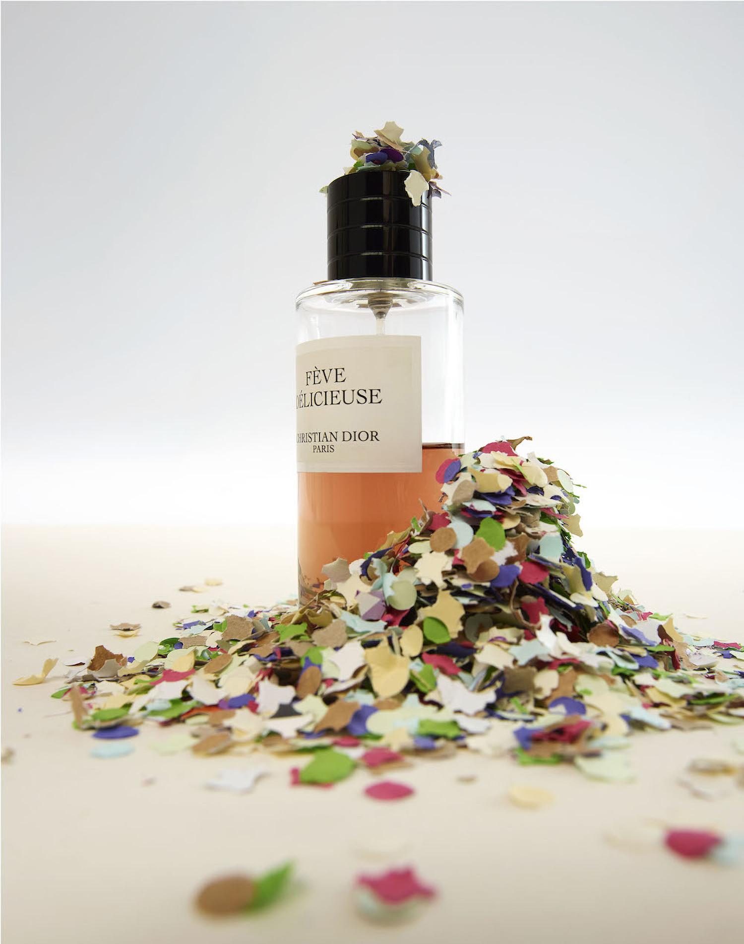 KMA photographer Daniel Schweizer shoots a bottle of perfume against a white background with rainbow confetti all over