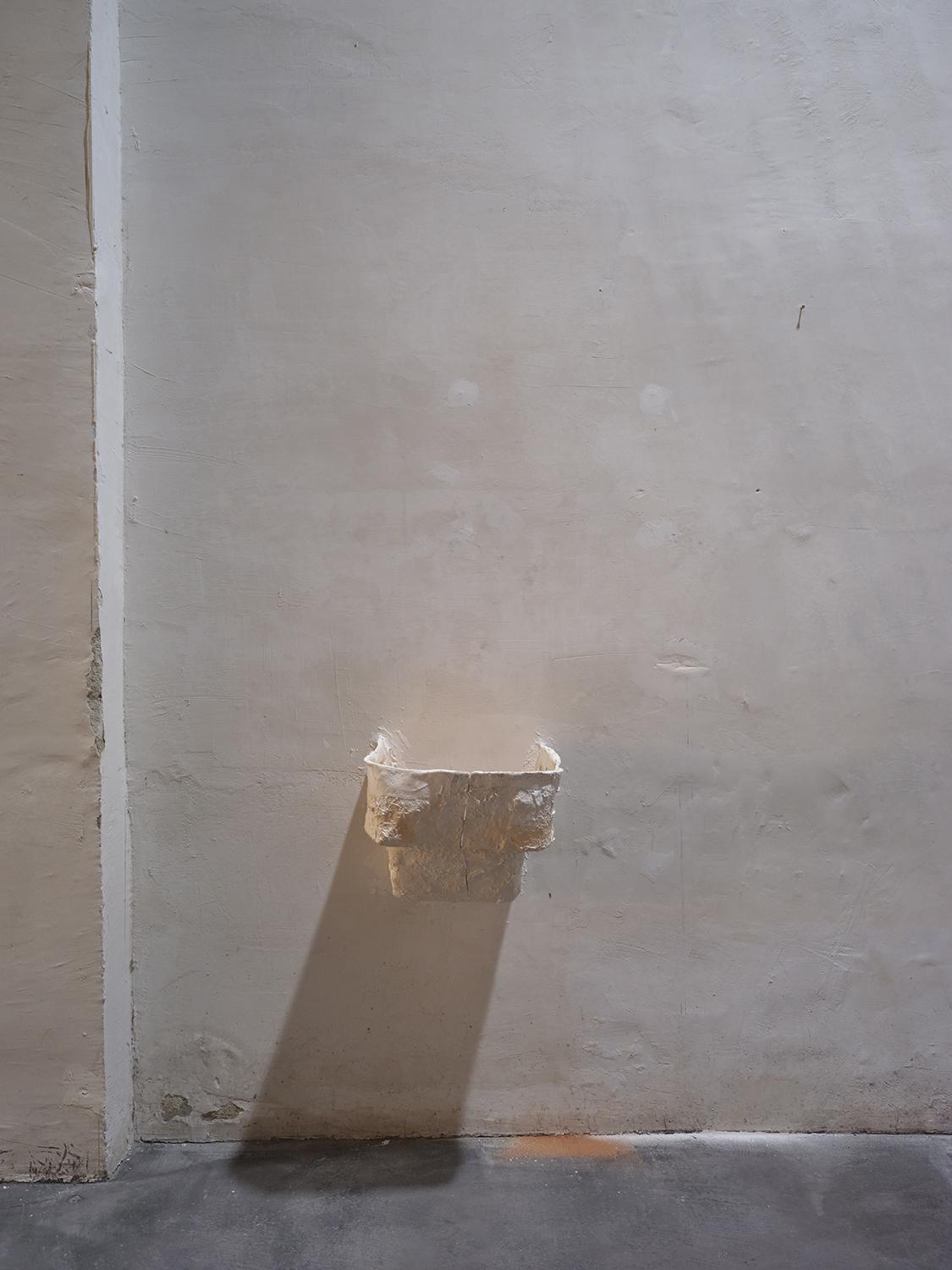 From hip to fingertip (Opel upside down), 2022. Remainder of the acrylic resin mould of the Opel Olympia sculpture made in collaboration between the artist and his father, putty on wall, iron rods and remains of the wall on the floor. 33,5 x 35,5 x 30 cm.