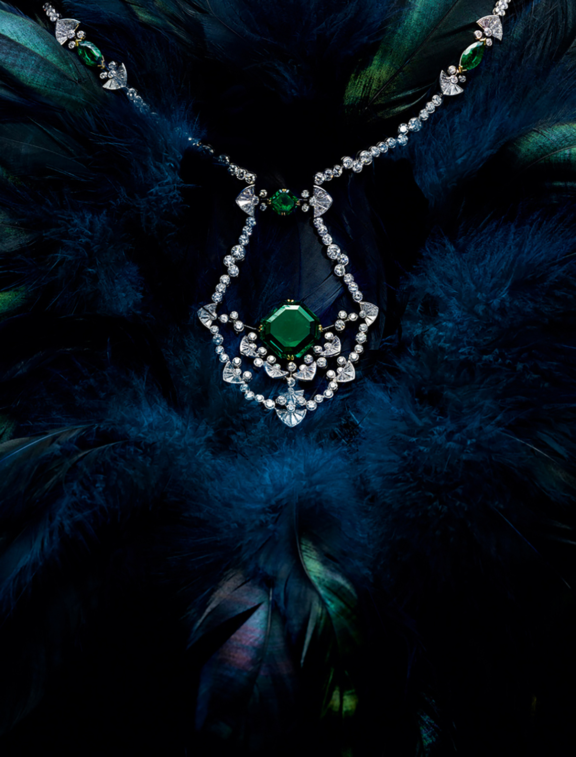 KMA photographer Isabelle Bonjean shoots photo of emerald and diamond necklace against blue background for Ritz Magazine