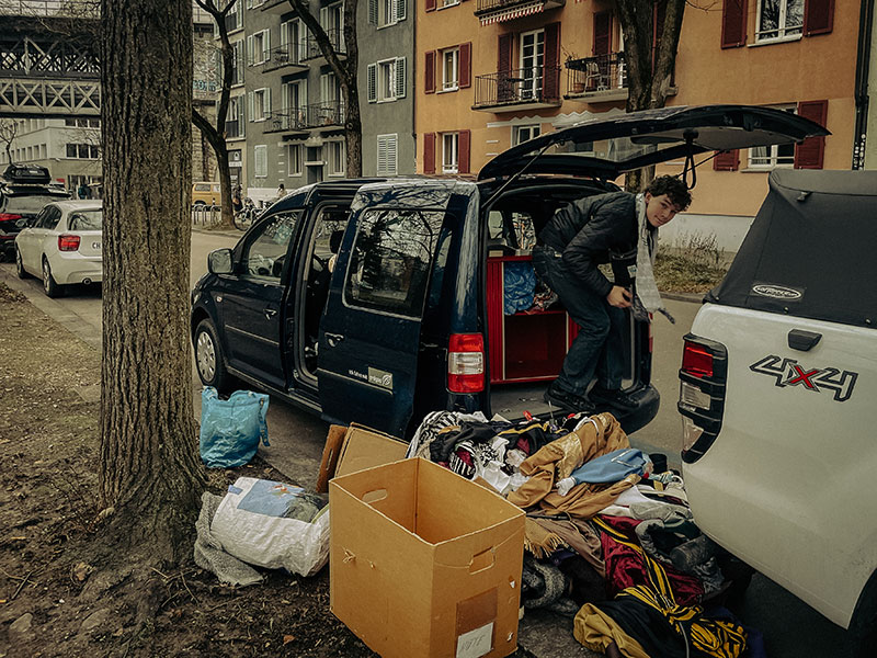 Mitten in Z&uuml;rich sortiert Cuno Kleidung und Masken auf einem Parkplatz.