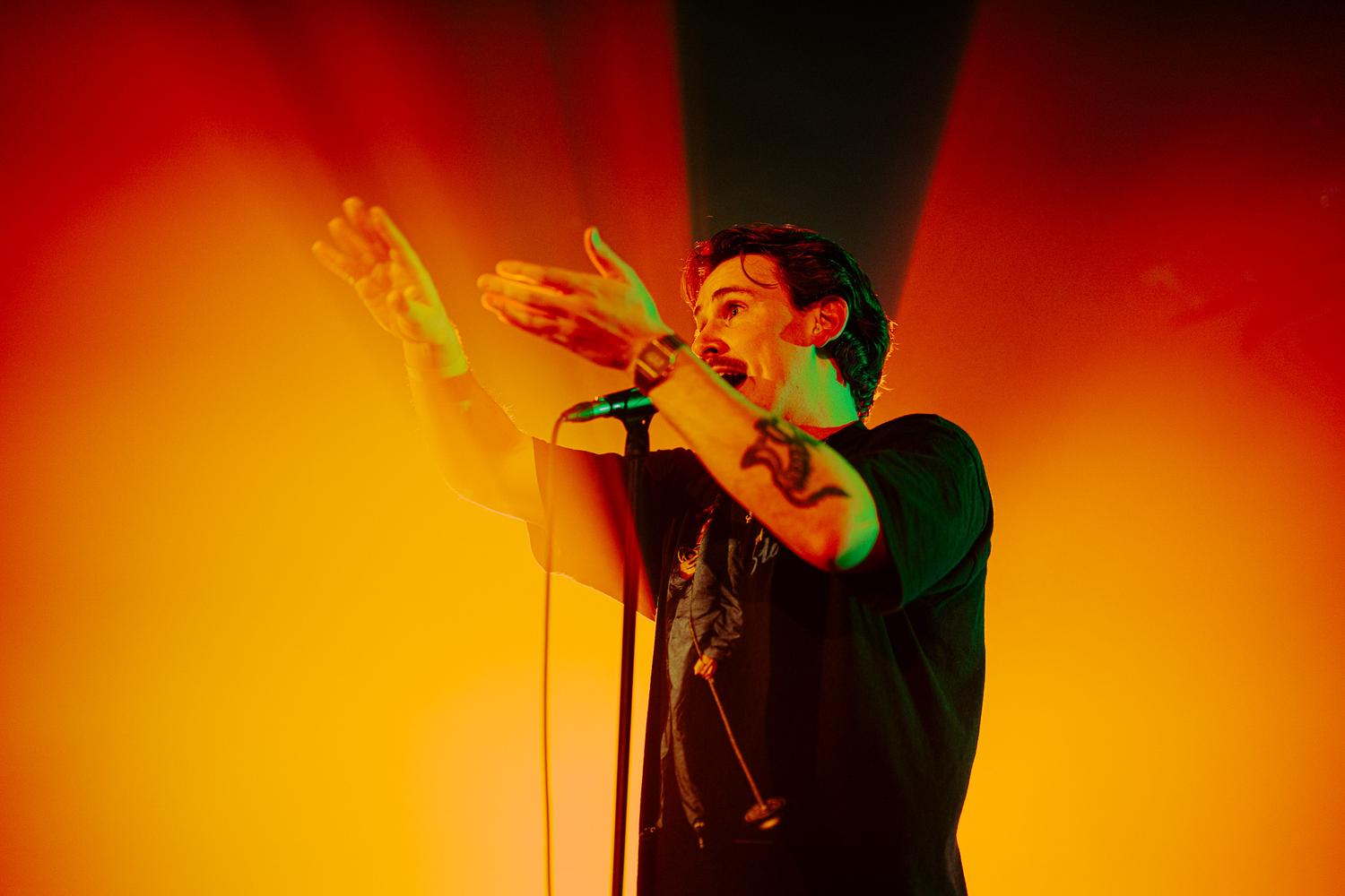 Kojaque performing live at EartH Hackney for AVA London, bathed in deep red stage lighting with AVA logo on screen.