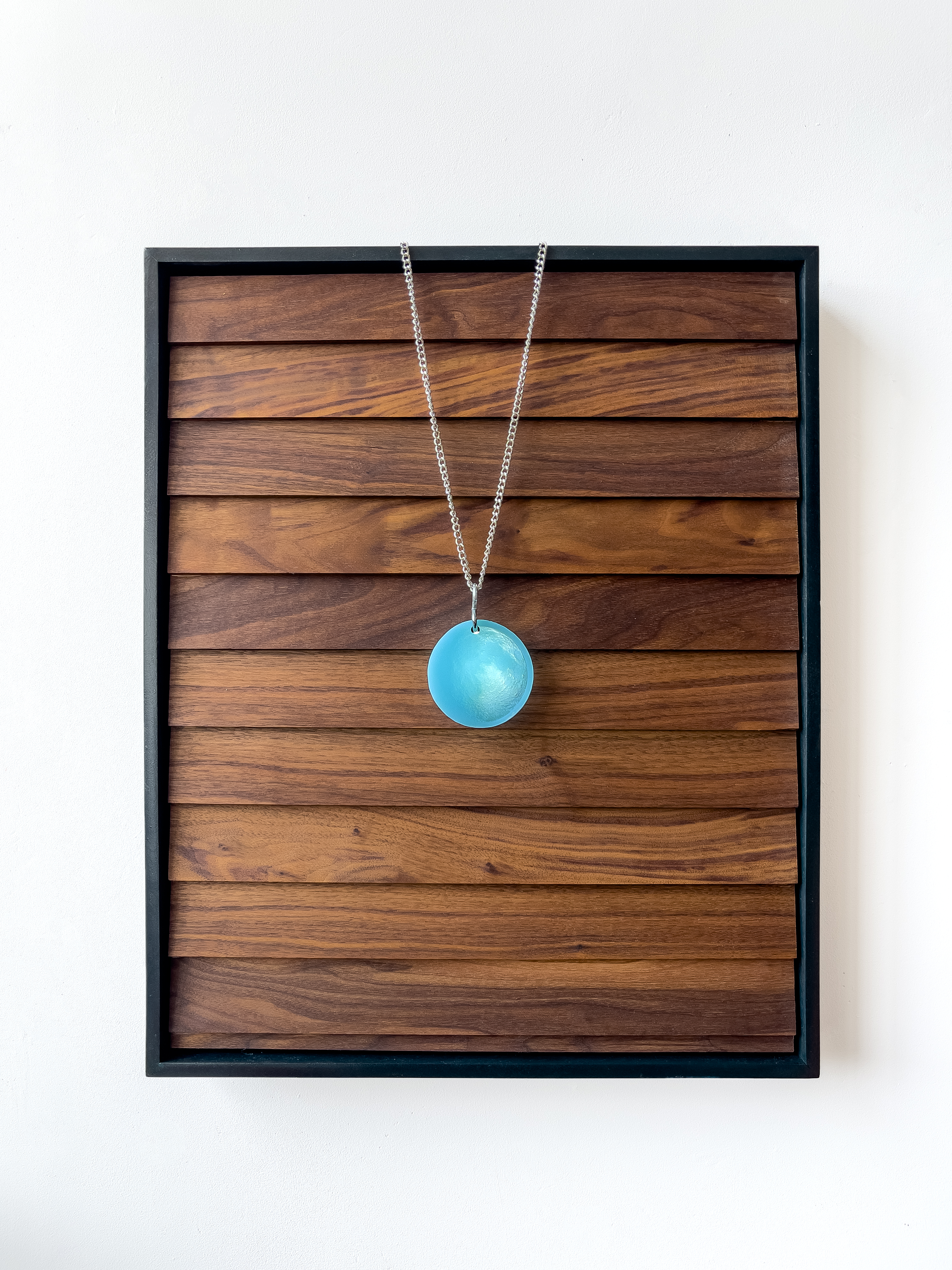 What Calm There Is in the Word Round, 2023, 21.5” x 17.5” x 3”. Wood, acrylic, polyurethane, danish oil, 3D printed photopolymer resin, steel chain, led light, hardware, power supply