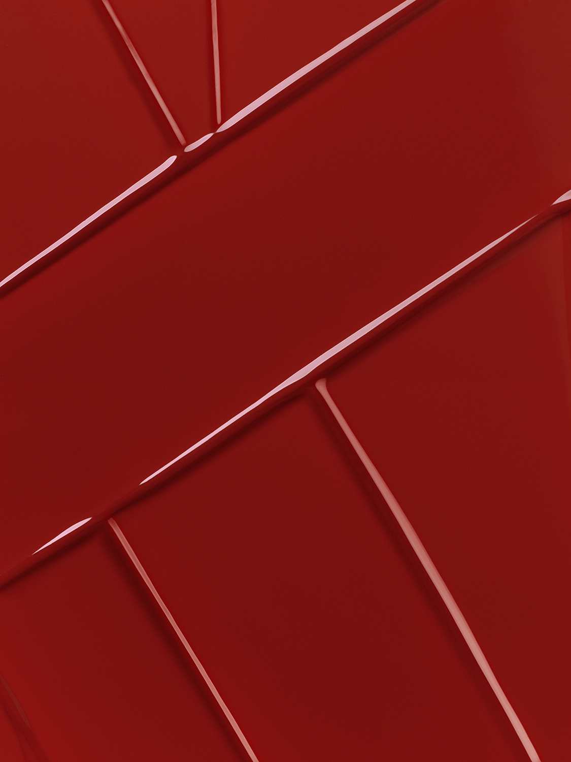 KMA photographer Mattias Nyhlin photographs a closeup of shiny red lipgloss smeared creating sharp lines for Max Factor