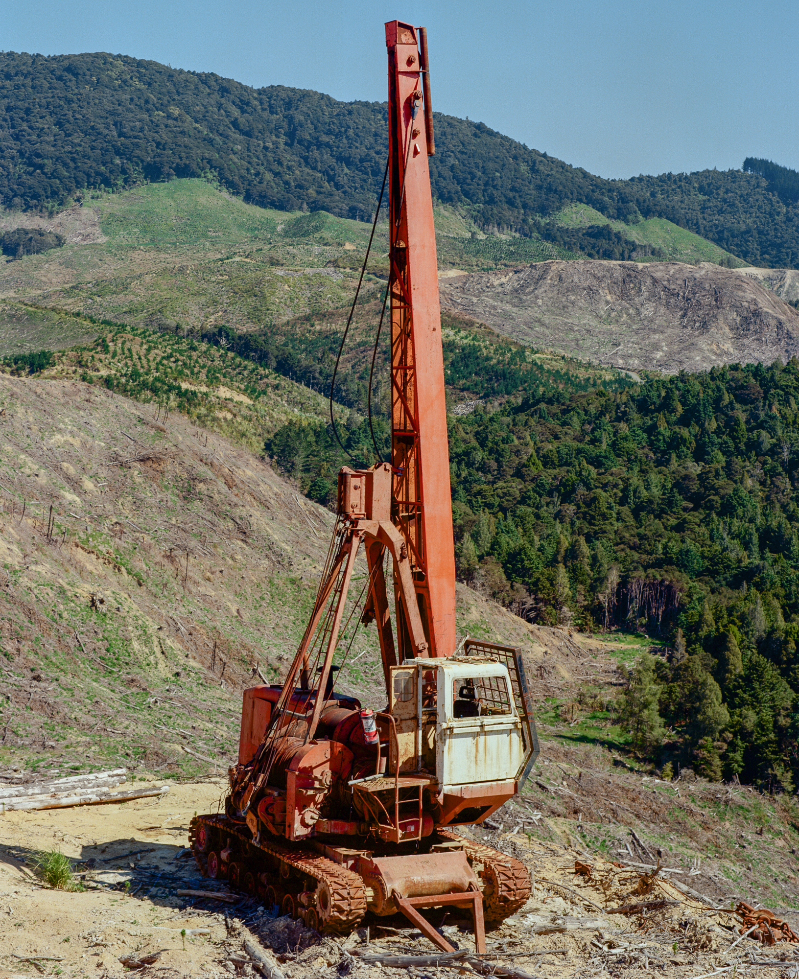 Sky haul machinery overlooking a patch of clear-cut land, several generations of pine forest in the background, Prime Farms, Mōtatau.Photograph by H. H.