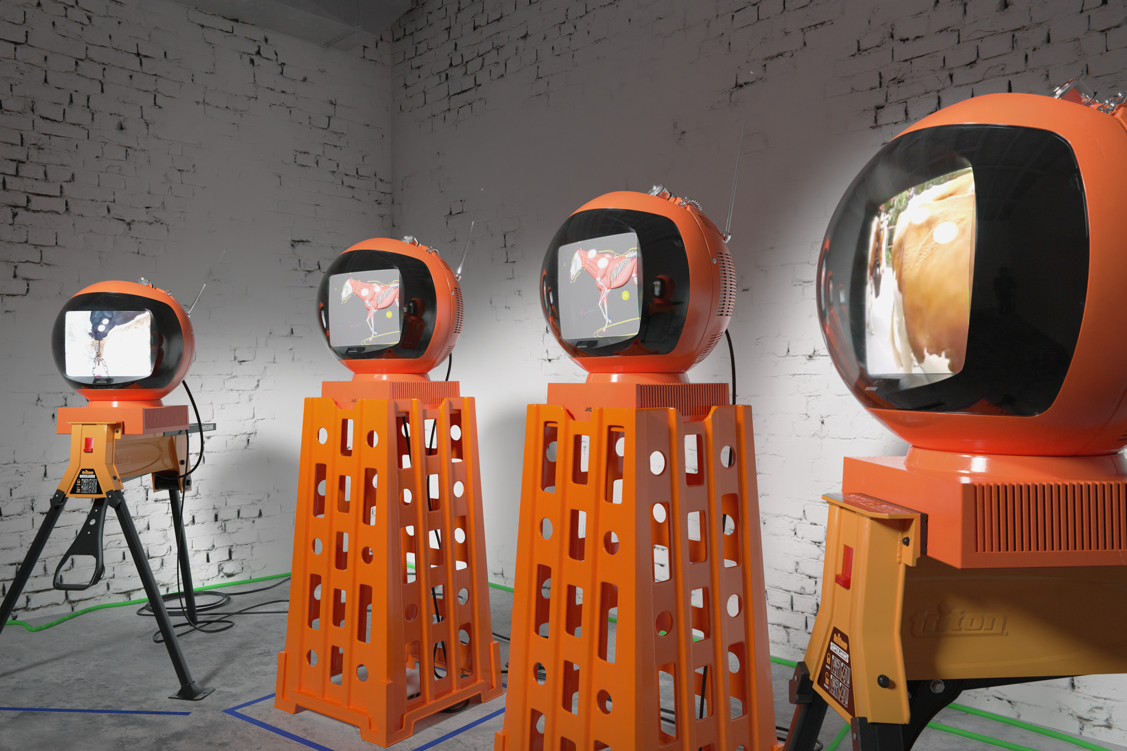 Echoes in an empty cage, 2023, refurbished videospheres, superjaw sawhorses, standtalls, media players, cables, tape, dimensions variable