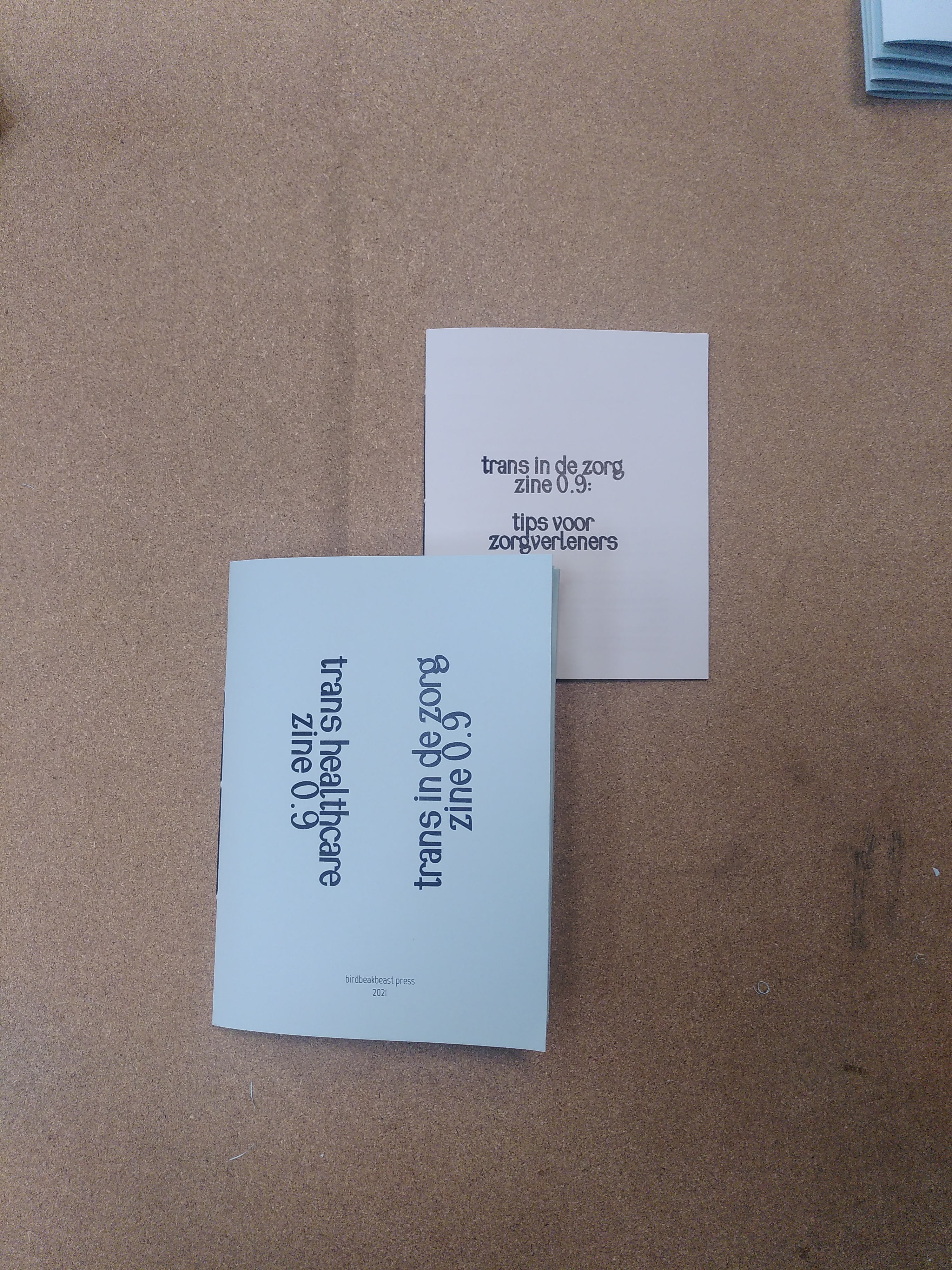 the mini-zine "trans in de zorg zine 0.9 : tips voor zorgverleners" peaks out of the parent zin "trans in healthcare zine 0.9 // trans in de zorg zine 0.9"