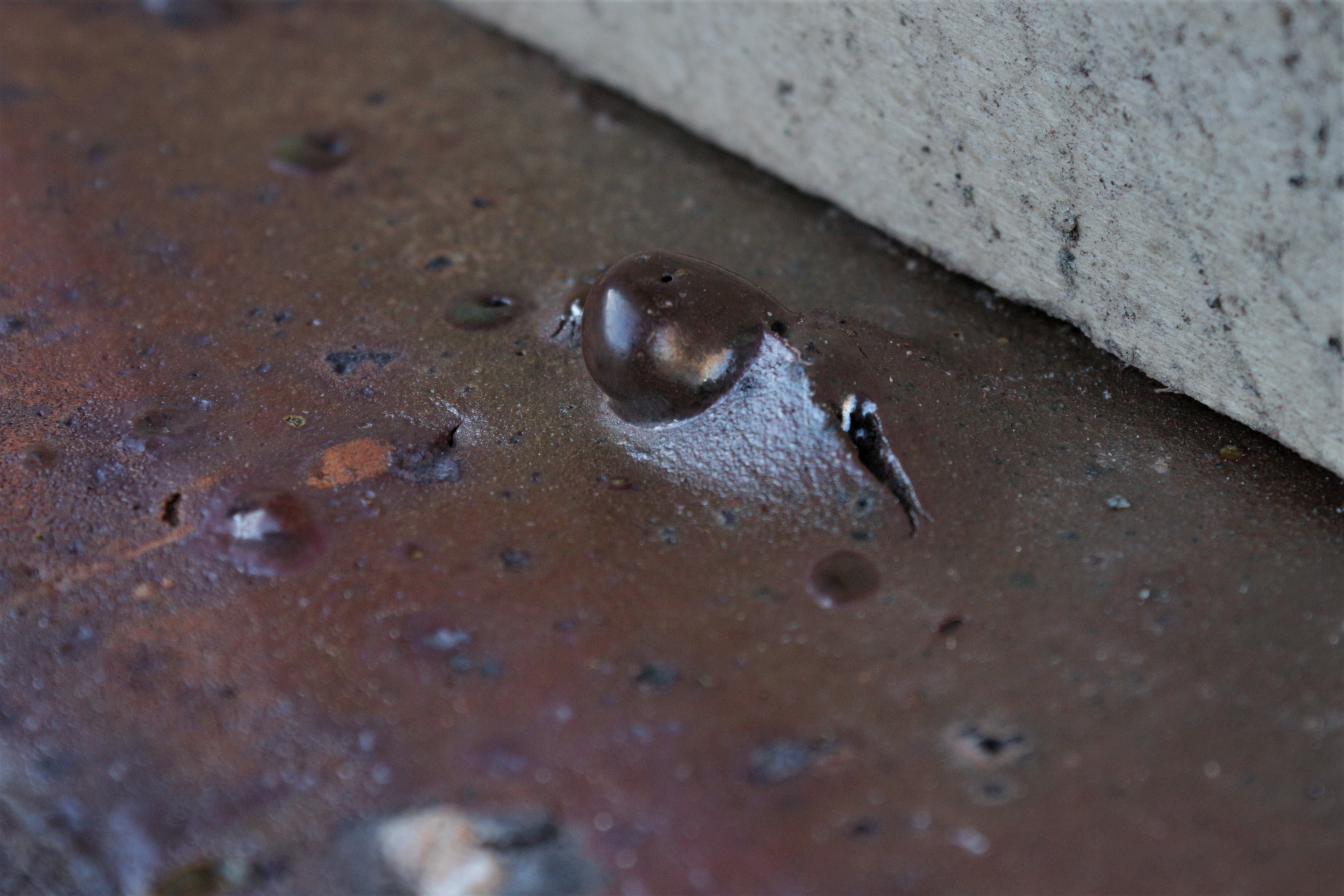 A bubble, melt from the siliceous earth, is solidified. Silica gives a glossy aspect to some bricks