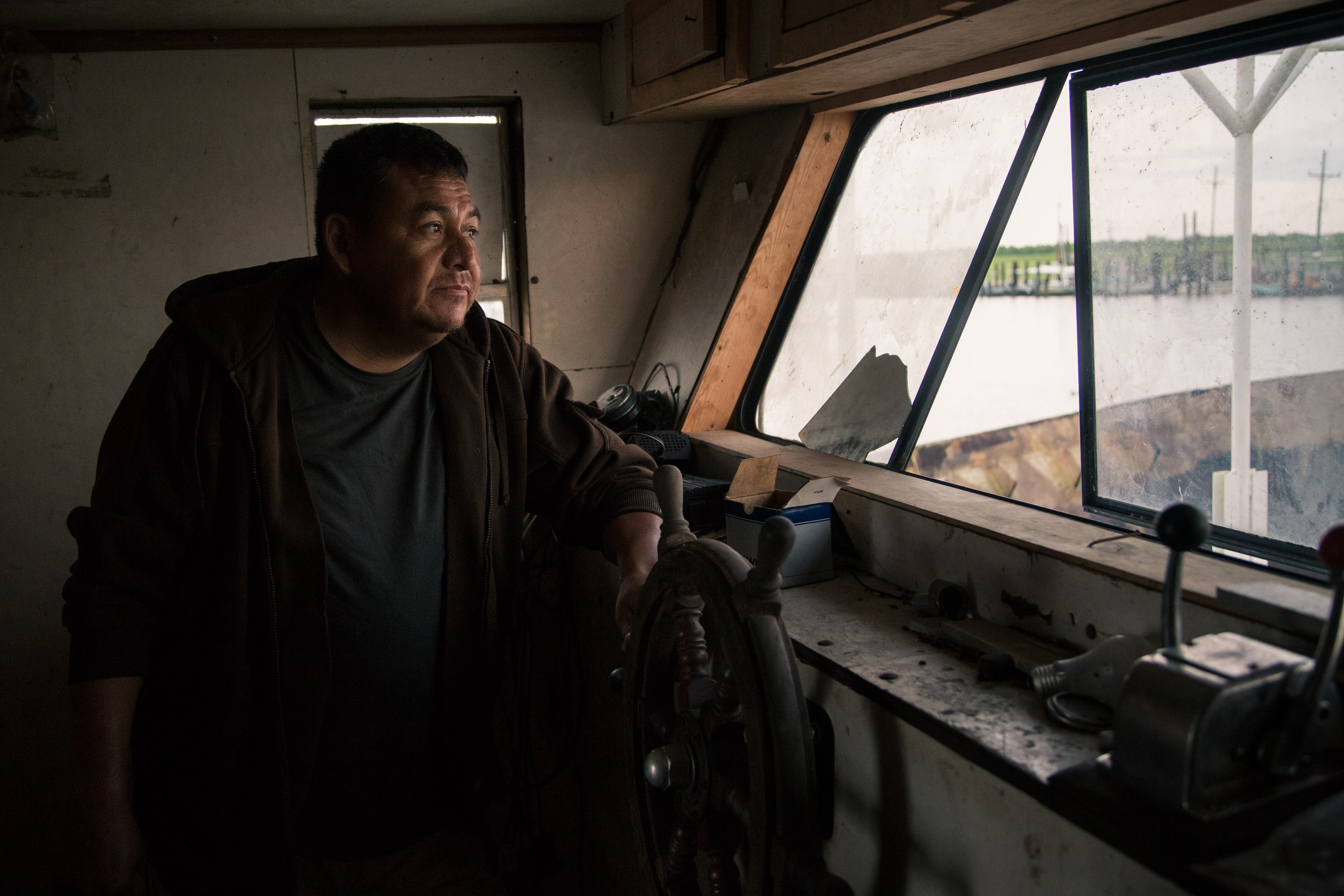 Pablo Cervantes inside his boat at the marina in Pointe a la Hache, La. This boat, he says, hasn't been used in over 3 years and is slowly falling apart. He moved from Mexico to Houma, La in 1992. He began working as an oysterman and fisherman and had four boats he worked from at several different marinas, at one time making $500,000 a year. He says the fishing on the east side of the Mississippi River where Pointe a la Hache is located is non-existent and that he now can only make a meager living fishing on the the west side in Barataria Bay working on other people's leased land.