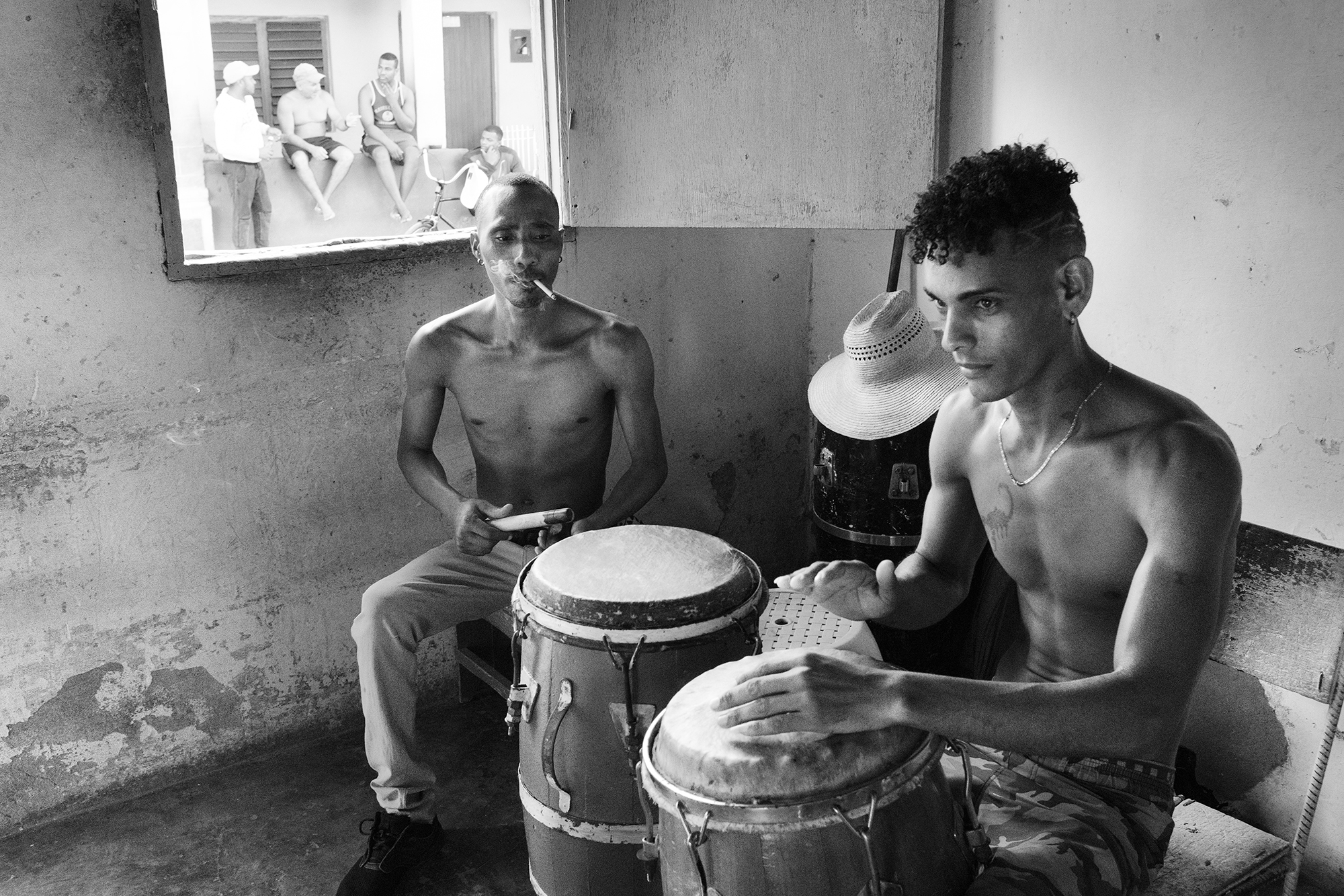 Philippe-Sarfati-soft-revolution-photography-photographer-street-documentary-cuba-castro-era-change-black-and-white-men-playing-percussions-in-their-home-outside-discussion-hat-trinidad