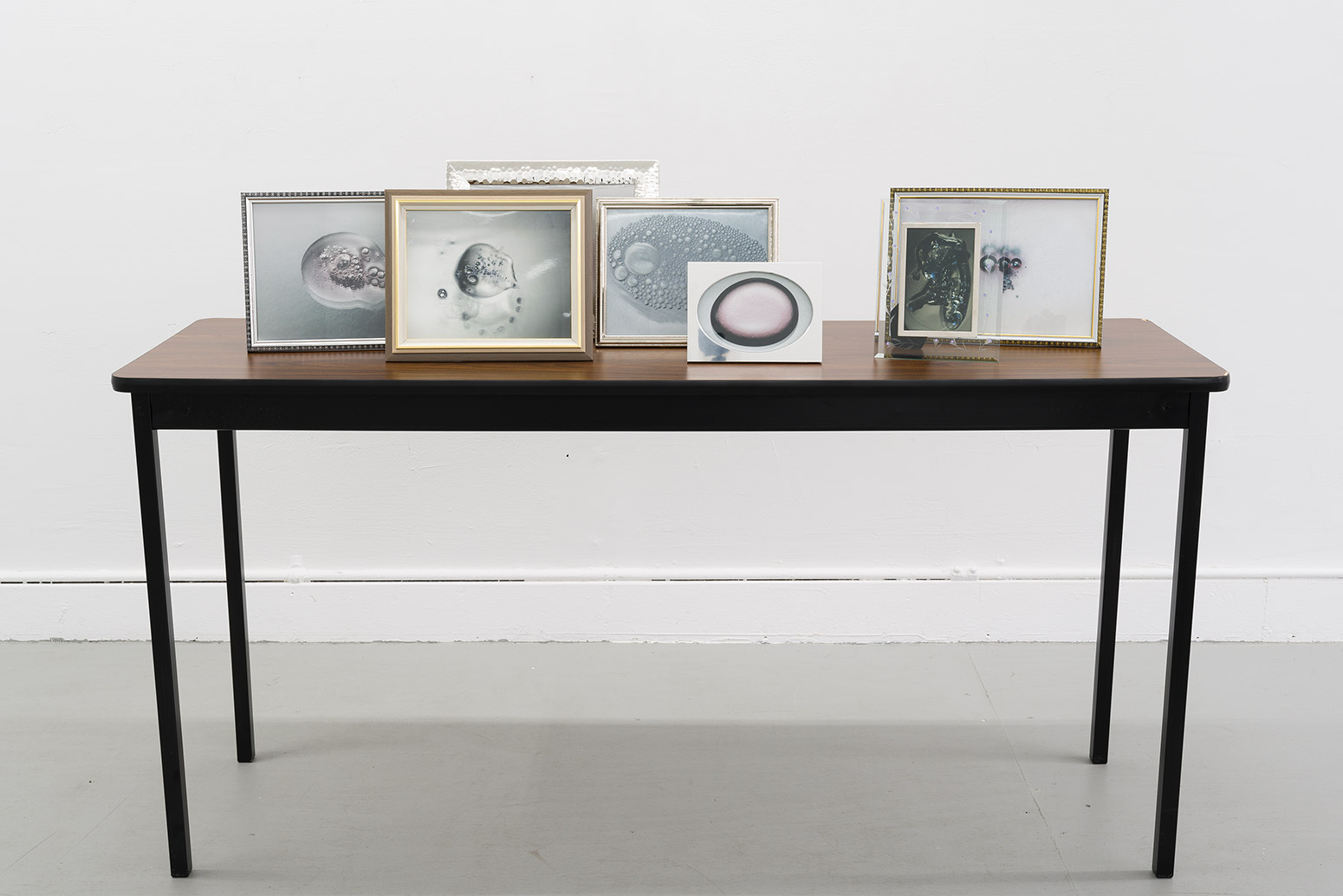 Vortex, 2024, prints, frames, table, 40 x 60 x 18 in. (101.6 x 152.4 x 45.7 cm.)