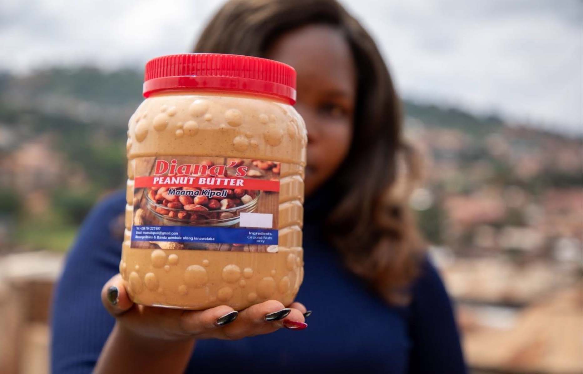 Diana montre un pot de beurre de cacahuète (kipoli) qu'elle fabrique et vend.