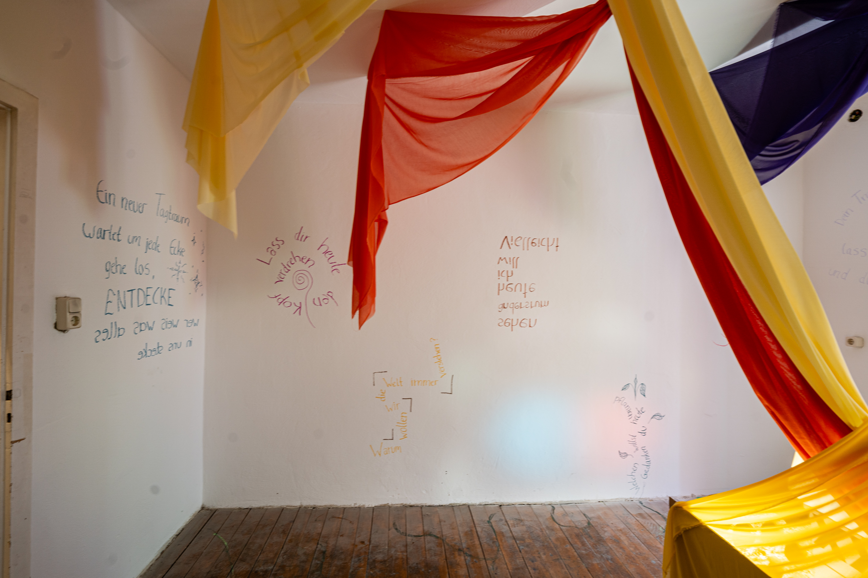 Bild 2 Poetree: An der Wand stehen handgeschriebene Gedichte. In verschiedenen Leserichtungen.