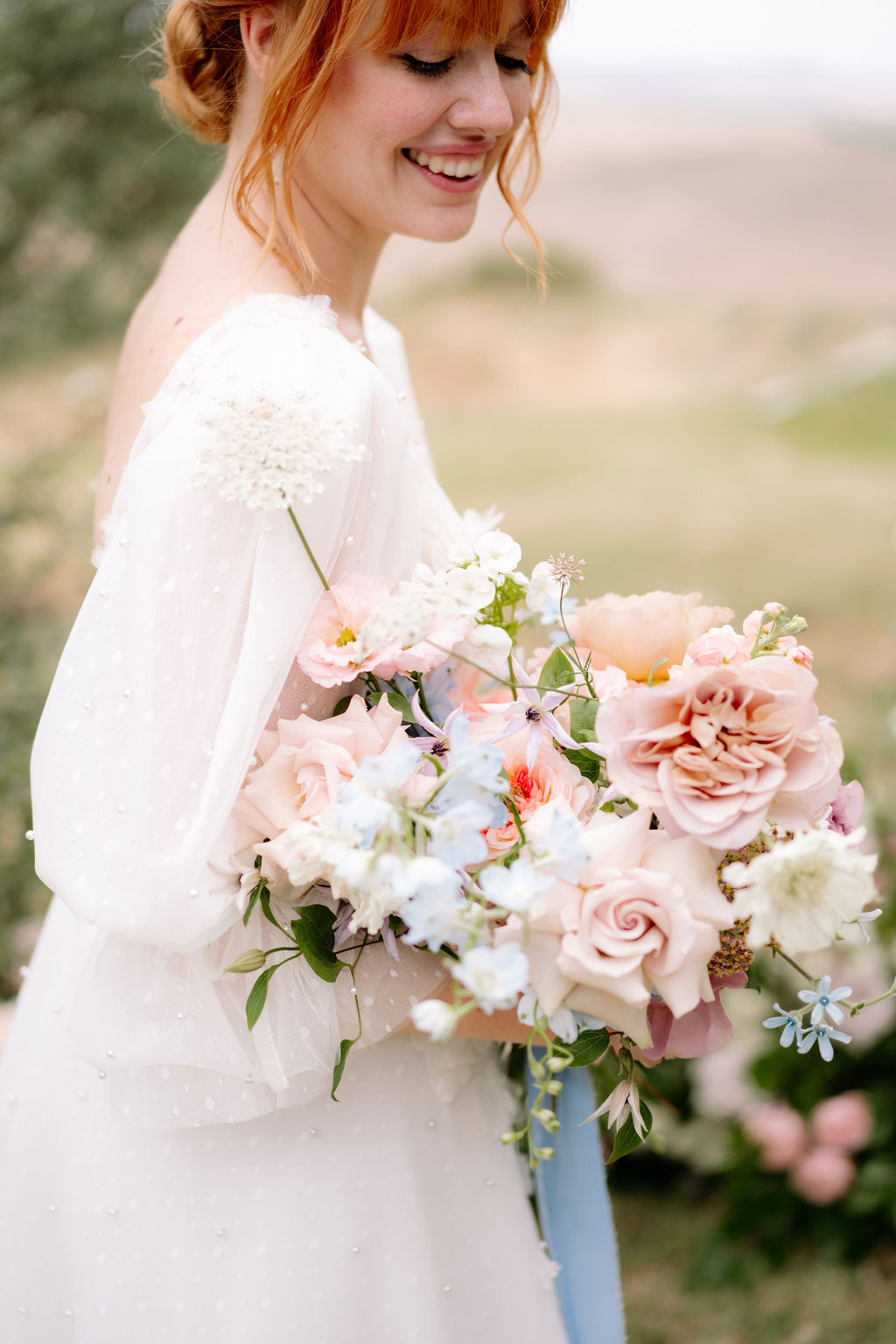 a woman in a wedding dress holding a bouquet of flowers