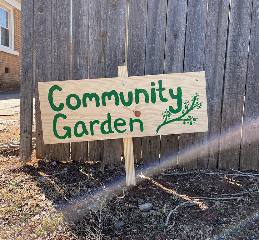 the hand-painted sign in front of the garden that says "community garden"