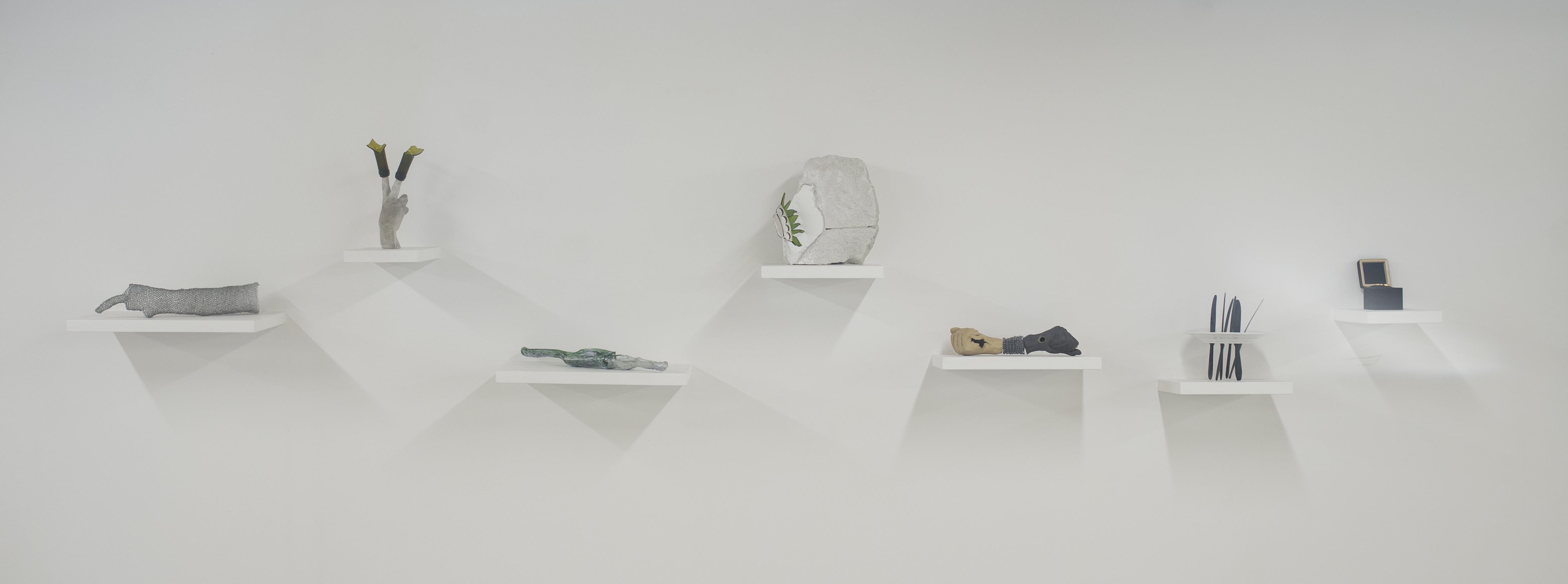 installazione a parete, mensole e sculture sul tema della mano