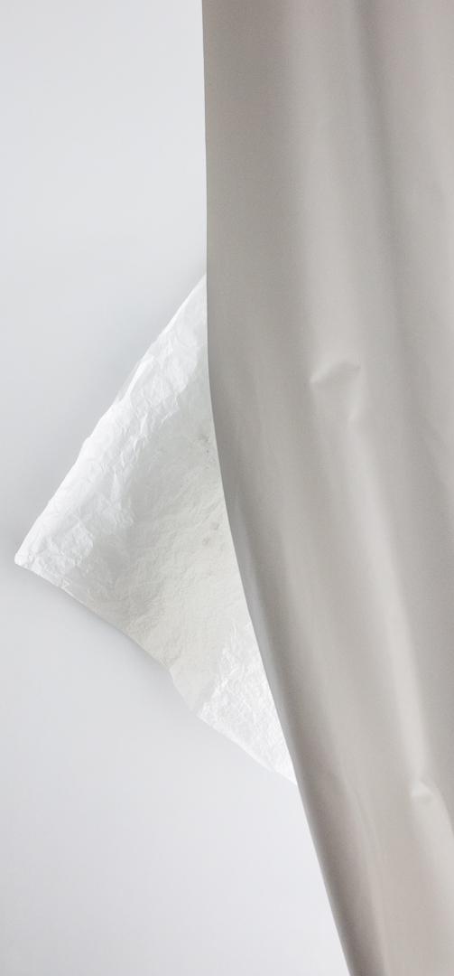 a white sheet of paper behind a gray curtain