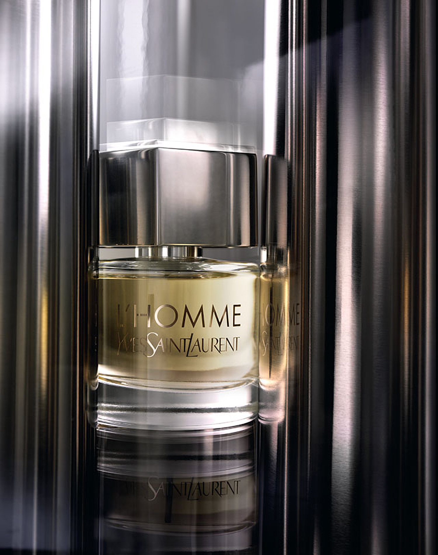 KMA photographer Daniel Schweizer photographs a gray and gold YSL perfume bottle with a shiny gray background 