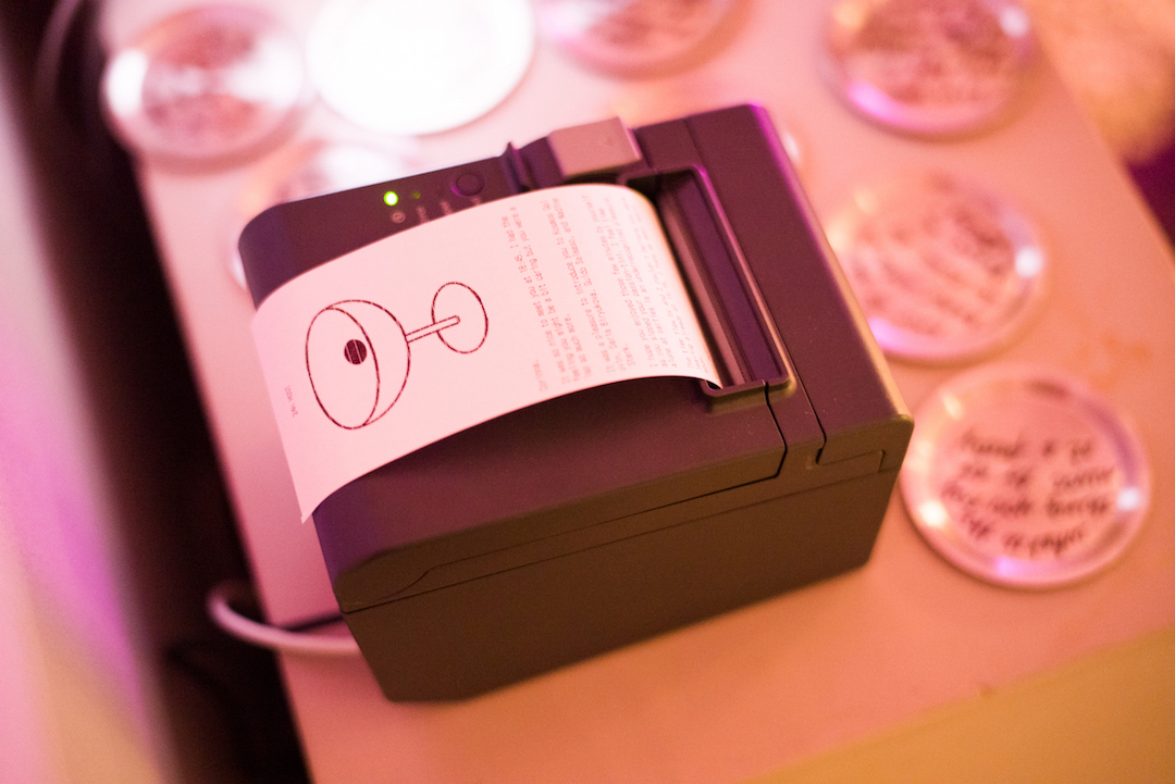 a receipt coming from the machine with a martini glass illustration on the top and text below.
