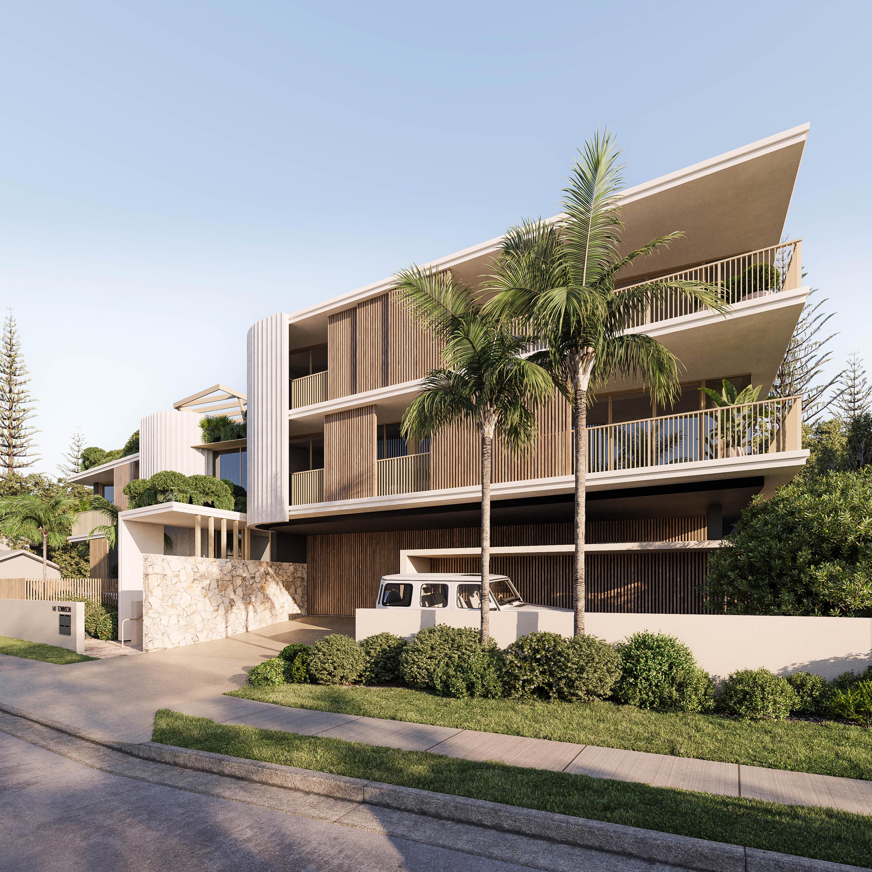 Modern three-story luxury apartments with white concrete, timber cladding, vertical wood screens, and large balconies. Elevated design with covered parking below, framed by palm trees and tropical landscaping, white SUV in driveway. Sunny day.
