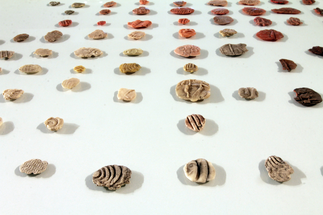 Sebastián PreeceChicles, andar por Curitiba, 2011Tres estructuras de fierro negro, base de madera melamina gris y cubierta de vidrio incoloro que contienen chicles77 x 75 x 125 cm c/uVer detalle︎