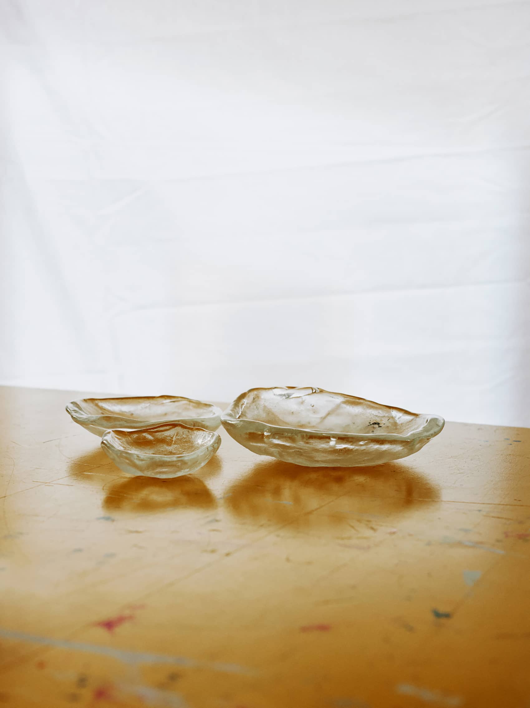 MOON PLATES FOR EQ3Moon Plates are artistic glass dishes created for EQ3 They are handmade, using sand molds, and are inspired by the moon's surface and its round shape. Each plate in the collection is unique, resembling the moon's texture and shape. They bring a sense of cosmic inspiration and showcase the craftsmanship put into their creation.Designed in collaboration with Laura BildeGo to product page →