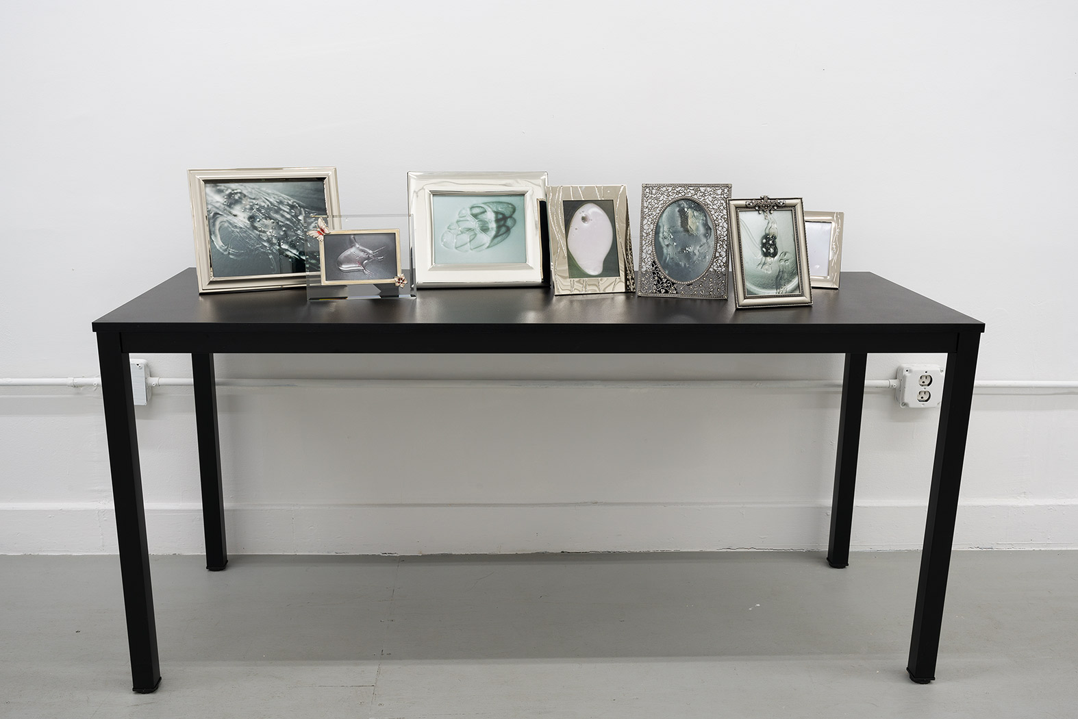 Foam, 2024, prints, frames, table, 38 x 63 x 24 in. (96.5 x 160 x 61 cm.)