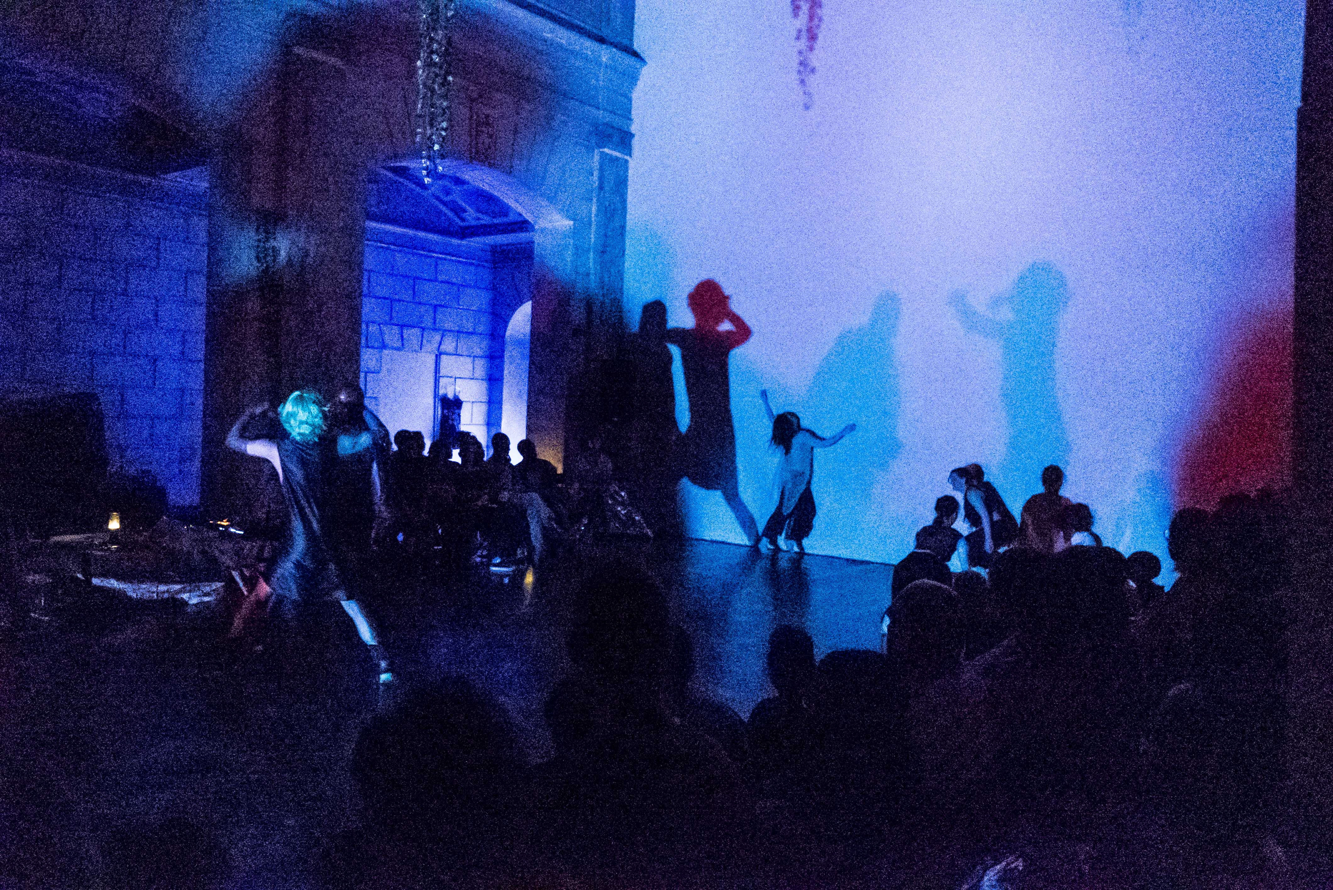 Photo by Cameron Kelly McLeod/ISSUE Project Room: from performance at ISSUE's theater, loveconductors perform with their shadows visible against the white wall in blue light