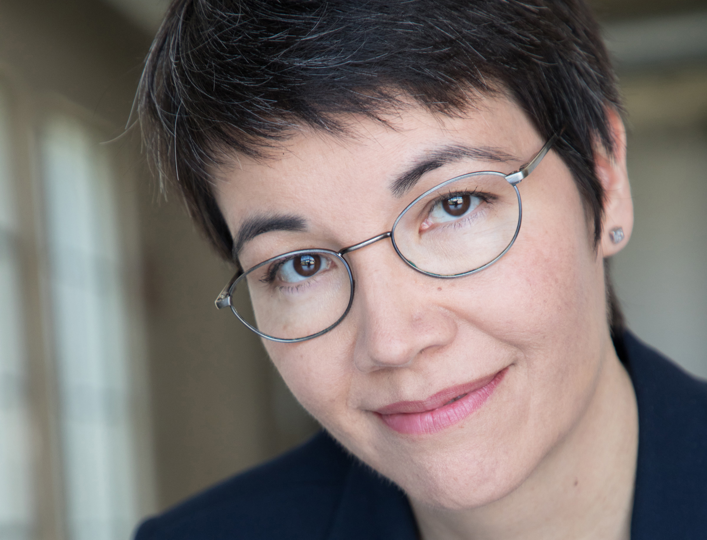 Headshot of Elizabeth Liang with eye-glasses gazing compassionately